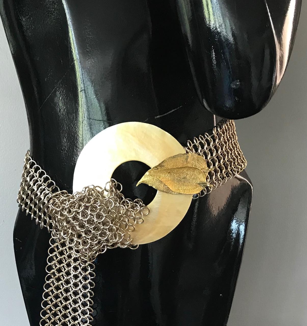 This necklace /belt is eco-luxe and sustainable. The materials used are gold iridescent mother of pearl/nacre and Vermeil  chainlink mesh. Two vermeil leaves are attached as enhancements on the mother of pearl. This piece can be worn as a belt or as