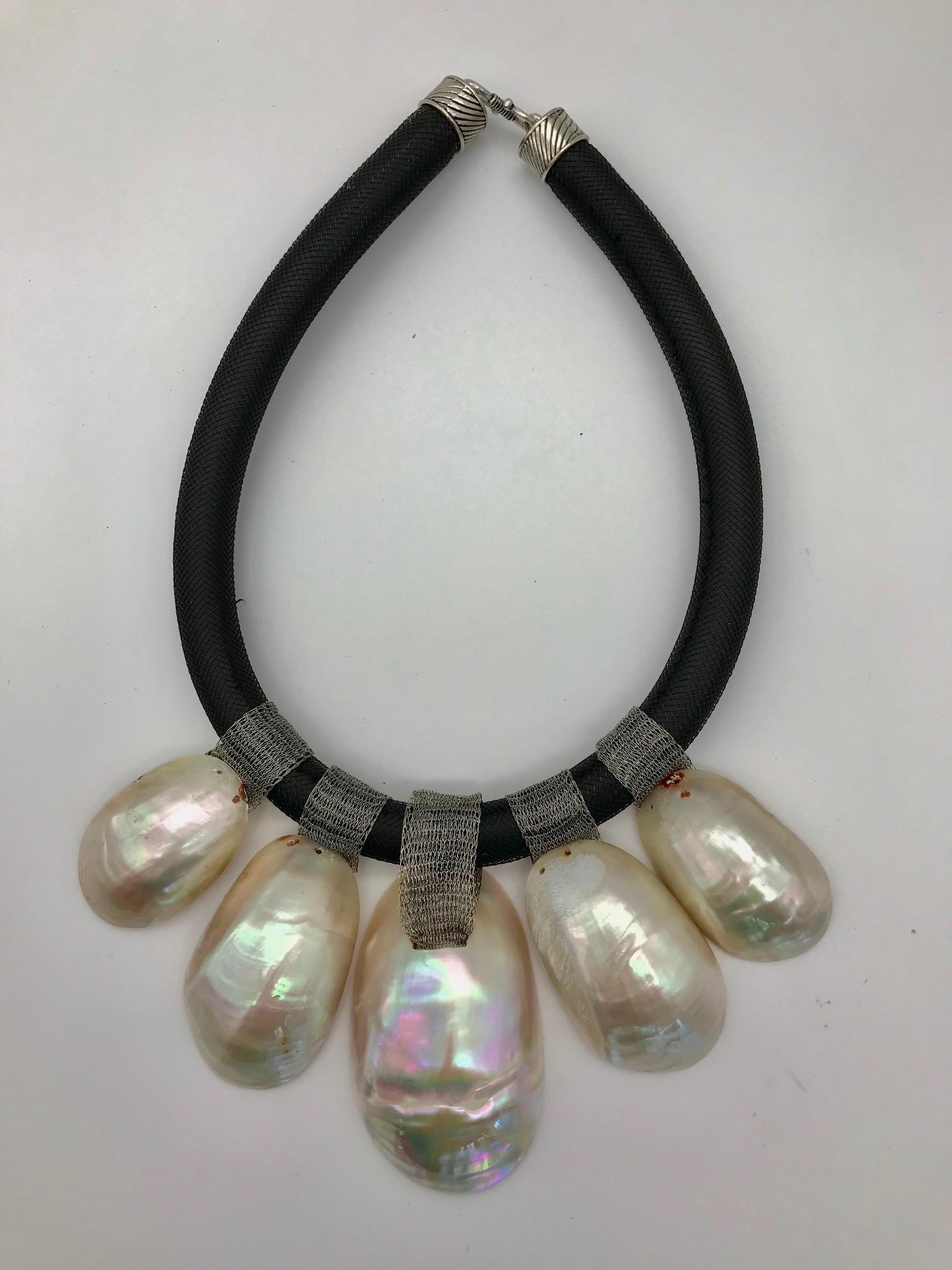 
This pink nacre Statement Necklace is eco–luxe and sustainable. The iridescent pink nacre used in this necklace has been up-cycled from hand cut and polished pieces produced during the French Deco period. Turbo was a favored material, for jewelry