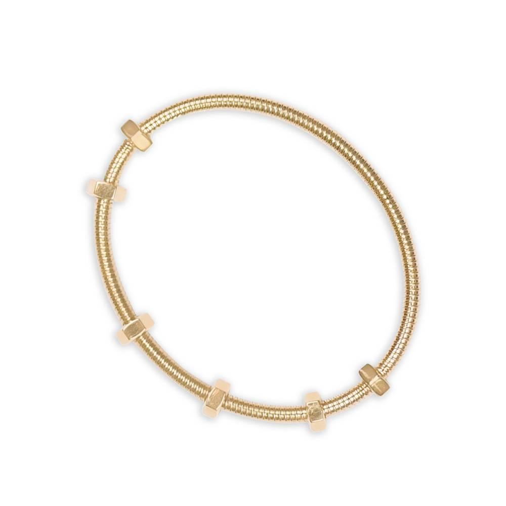 An Ecrou de Cartier bracelet showcasing the iconic hexagonal nuts along a screw design bangle, crafted in 18k yellow gold. The Cartier signature is elegantly featured on one of the nuts, and the piece comes with its original Cartier paperwork.
This