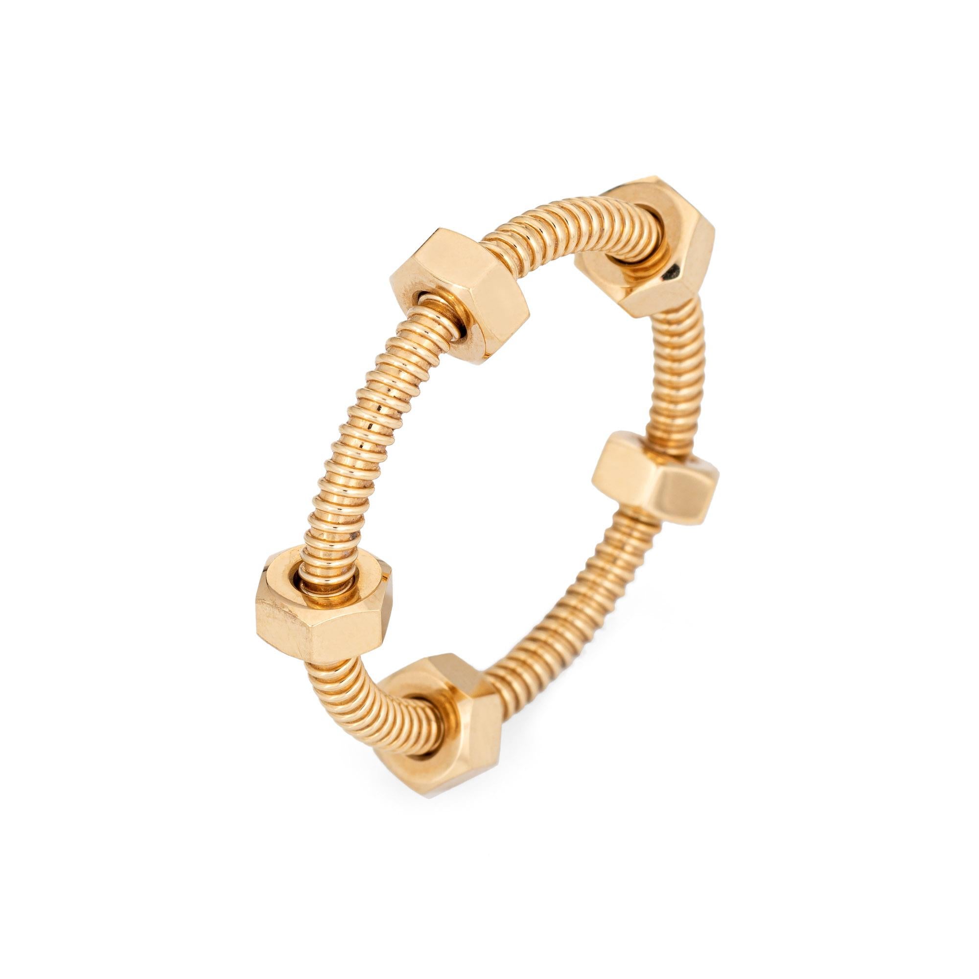 Ecrou de Cartier ring crafted in 18 karat yellow gold (circa 2018).  

'Ecrou' means 'nut' in French, as in the hardware. The ring has an industrial feel with a luxurious spin. The 'nuts' are designed to move smoothly along the ring in 360 fluid