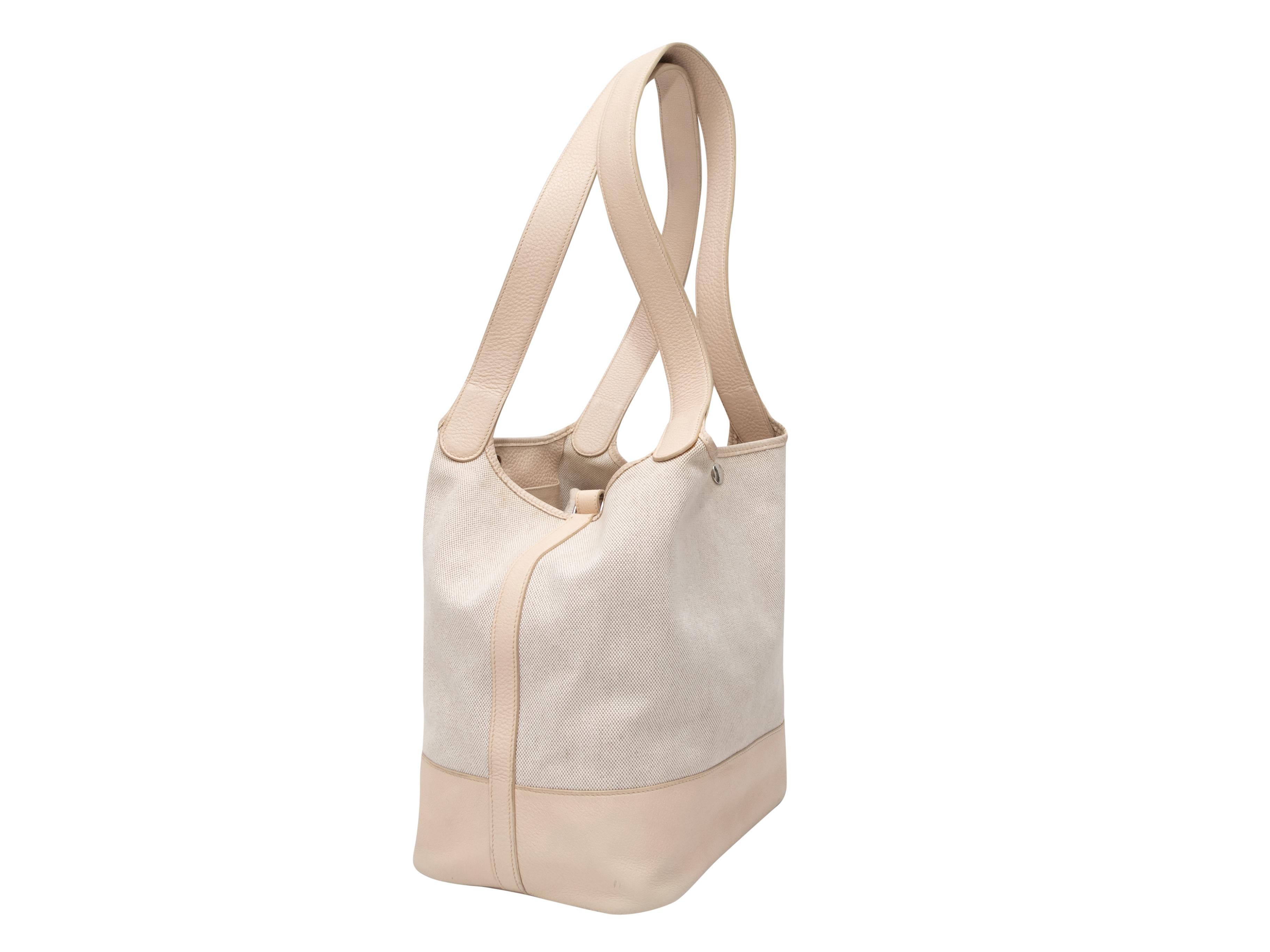 Ecru Hermes 2007 Toile Picotin GM Bag. The Toile Picotin GM Bag features a leather and canvas body, silver-tone hardware, dual flat shoulder straps, and a top snap closure. 13