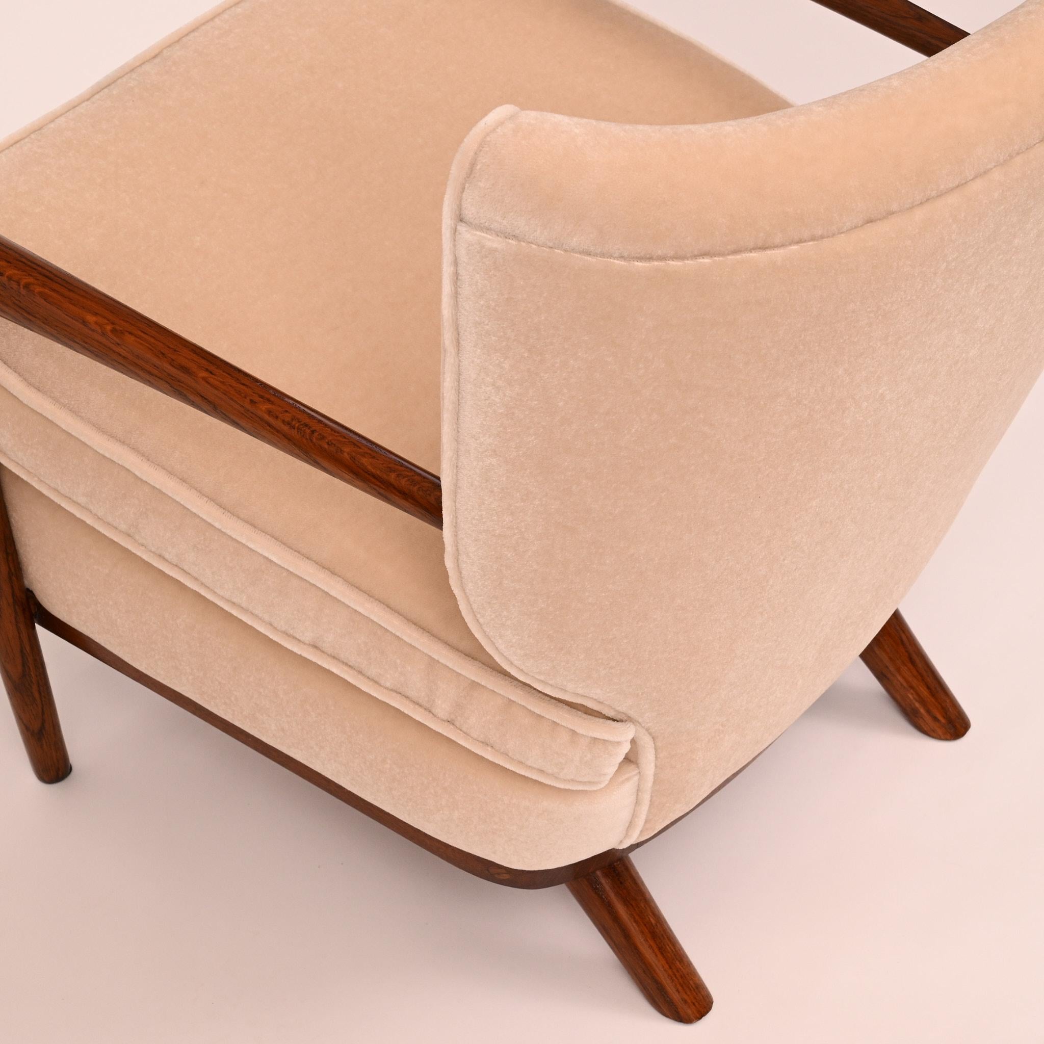 The Ecusson armchair (part of a set - sofa, 3 armchairs and coffee table), designed by renowned French decorator Jean Royère in the 1950s, exemplifies his distinctive style of elegant whimsy. With its shield-shaped backrest,  the chair combines