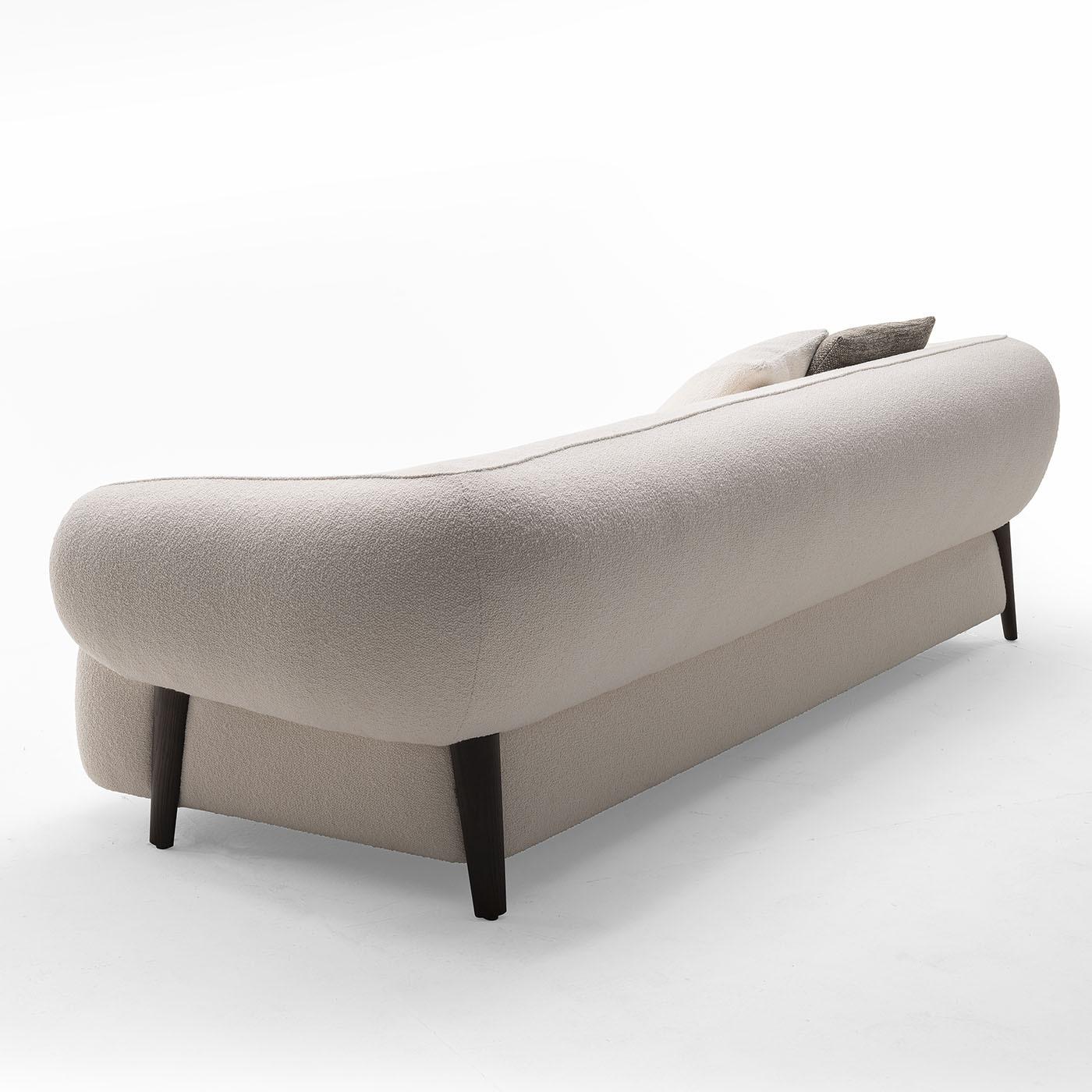 As bold as it is minimalist, this three-seater sofa promises moments of impeccable comfort spent against its plump and enveloping volumes. The rich padding - characterizing both the seat and the backrest with slightly sloped armrests - comes sealed