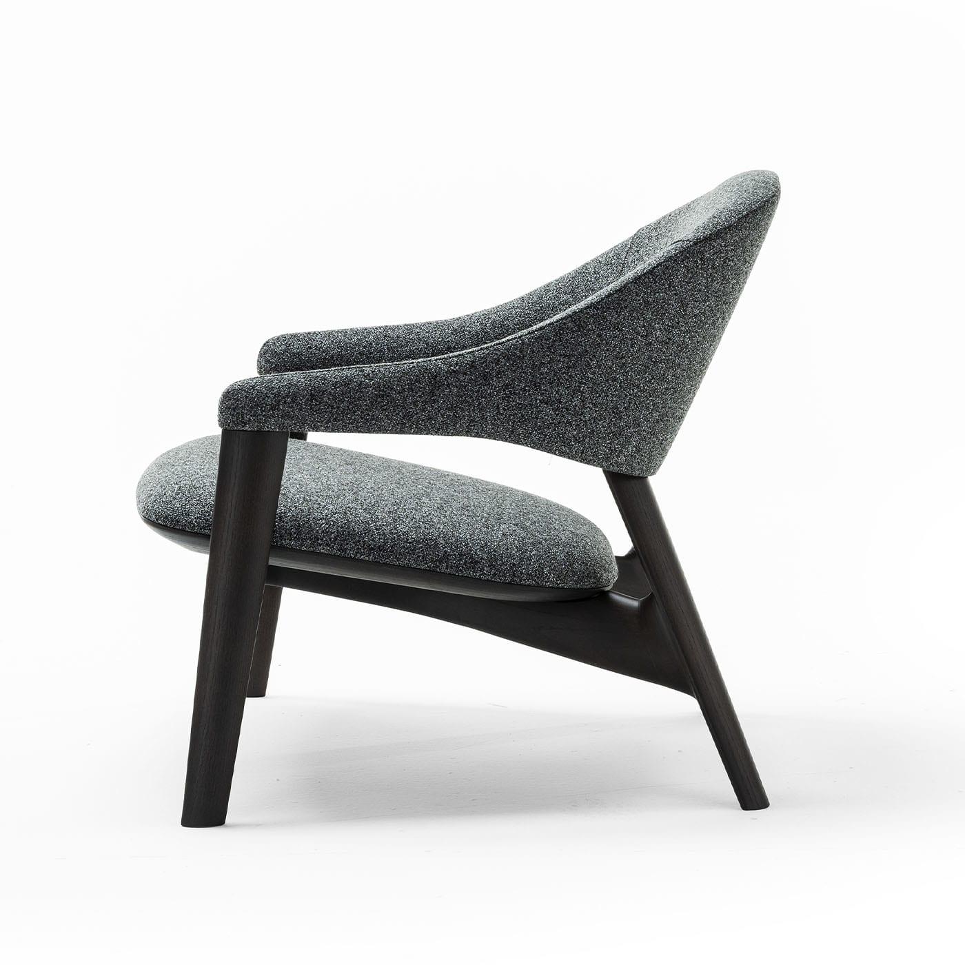 Enveloping curves also tracing sloped profiles for an experience of impeccable comfort define this armchair, a modern-style piece equally apt for suiting residential or professional settings. A refined gray melange fabric seals the wide inclined