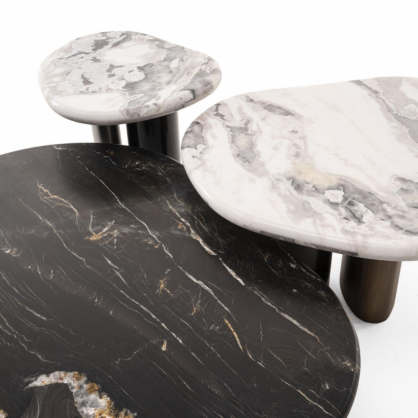 A sculptural silhouette enhanced by superbly contrasting finishes lends this side table its captivating charm. The prized Dover marble top captures the eye with its singular veins and cloud-inspired contours, while the couple of oval-cut and