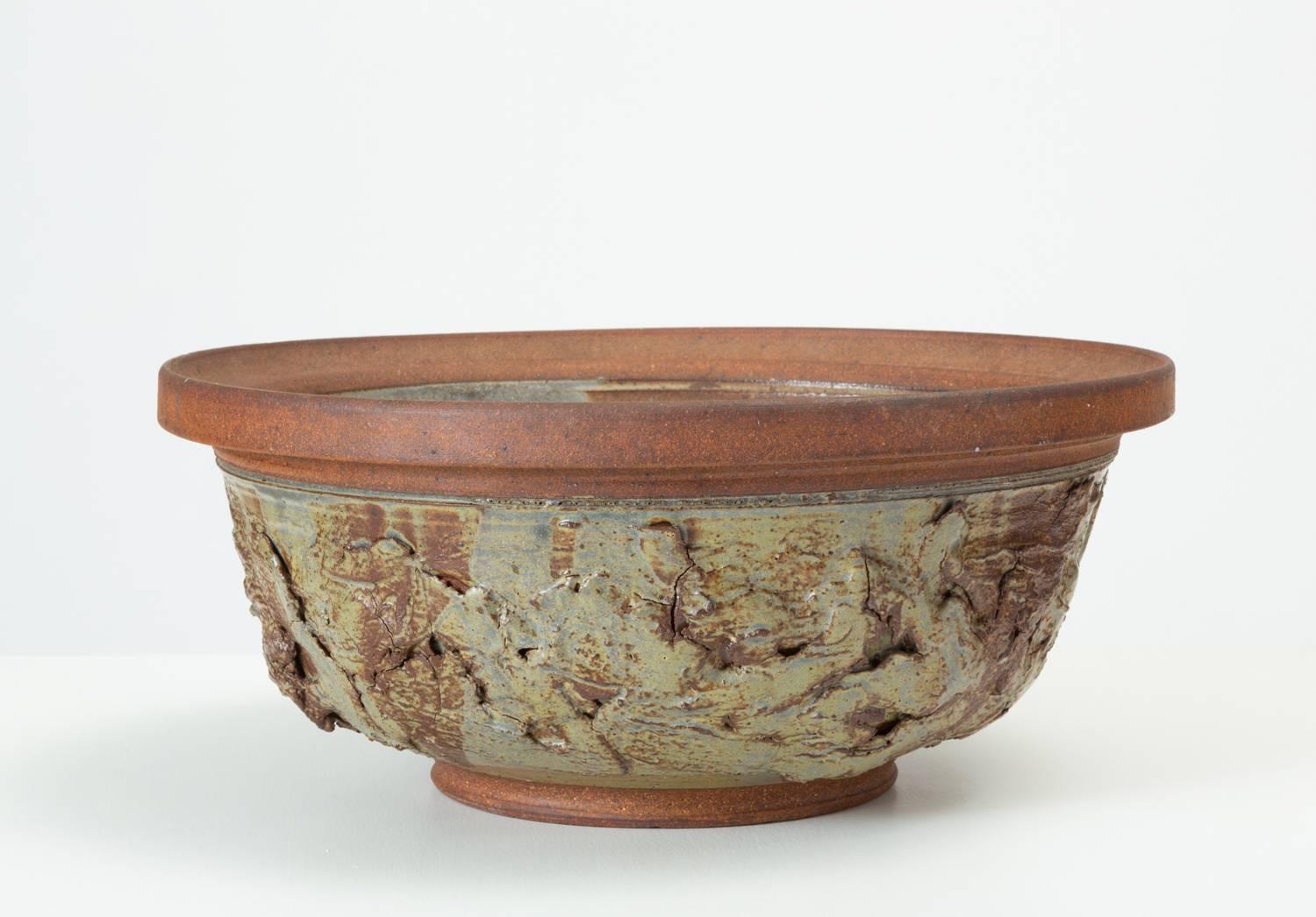 A 1970s large stoneware bowl by Alberta, Canada-based potter Ed Drahanchuk. His studio works were made from local clays and often featured hand-built appliqués, giving a rough-hewn and organic impression. This partially glazed pieces has an