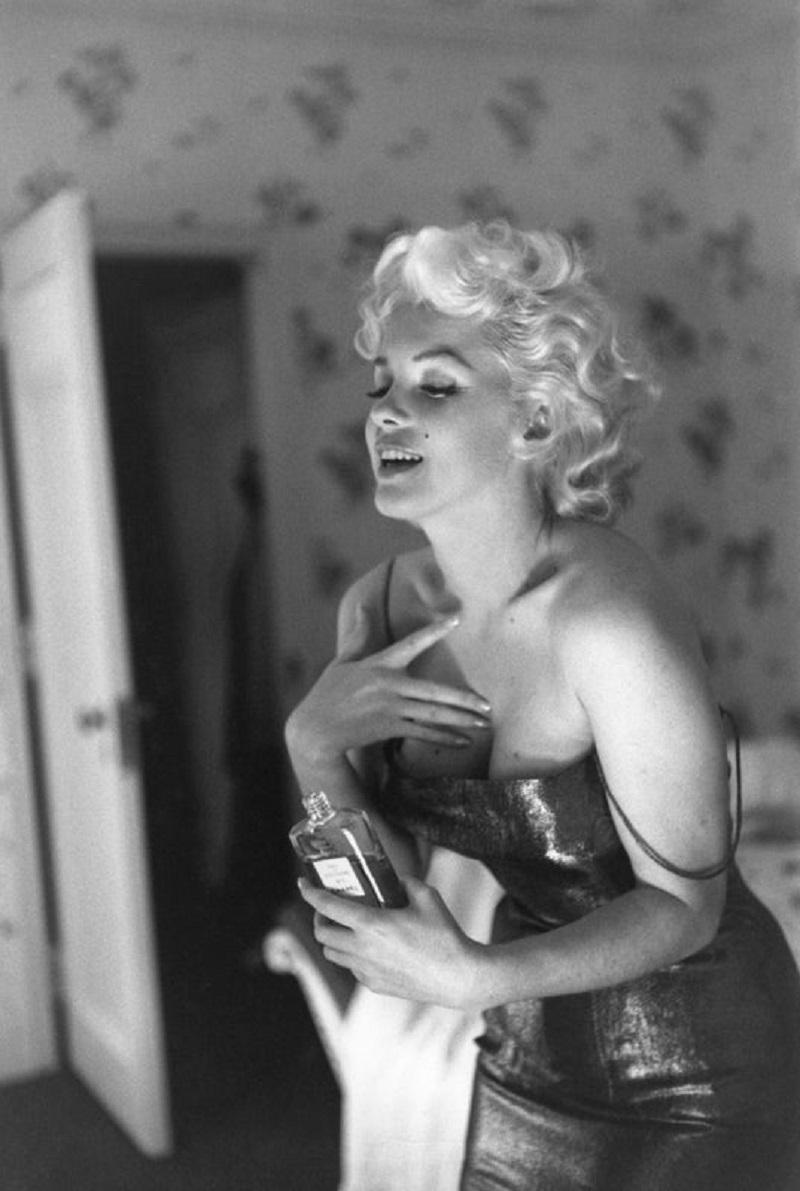 "Marilyn macht sich bereit zum Ausgehen" von Ed Feingersh

Die Schauspielerin Marilyn Monroe bereitet sich auf die Aufführung des Stücks "Die Katze auf dem heißen Blechdach" vor und trägt spielerisch ihr Make-up und das Parfüm Chanel Nr. 5 auf. Am