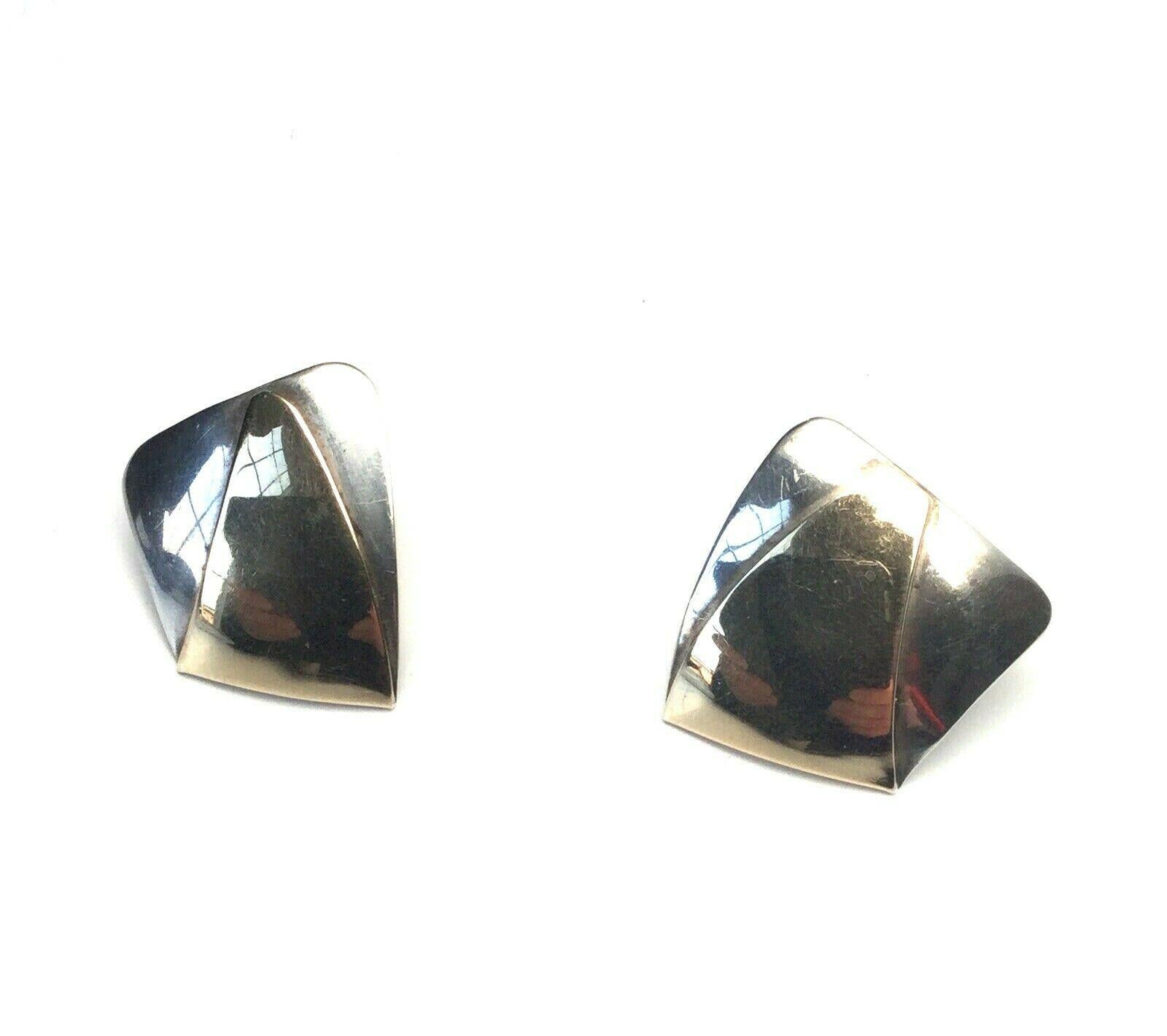 This is an amazing pair of 14K gold and sterling silver modernist earrings designed by Ed Levin.

Measurement:  20mm x 18mm, measures front to back with post 10 mm. 

Weight:  6.4  g /  4.1 dwt

Condition:  In good condition with some surface