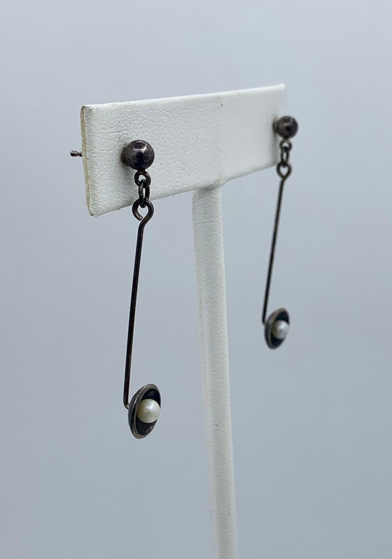 This is a stunning pair of early signed Ed Levin Mid-Century Modernist Dangle Drop Earrings in Sterling Silver with Pearls set in a black anodized silver disc.  The earrings exude the classic early Ed Levin design and they dangle wonderfully from