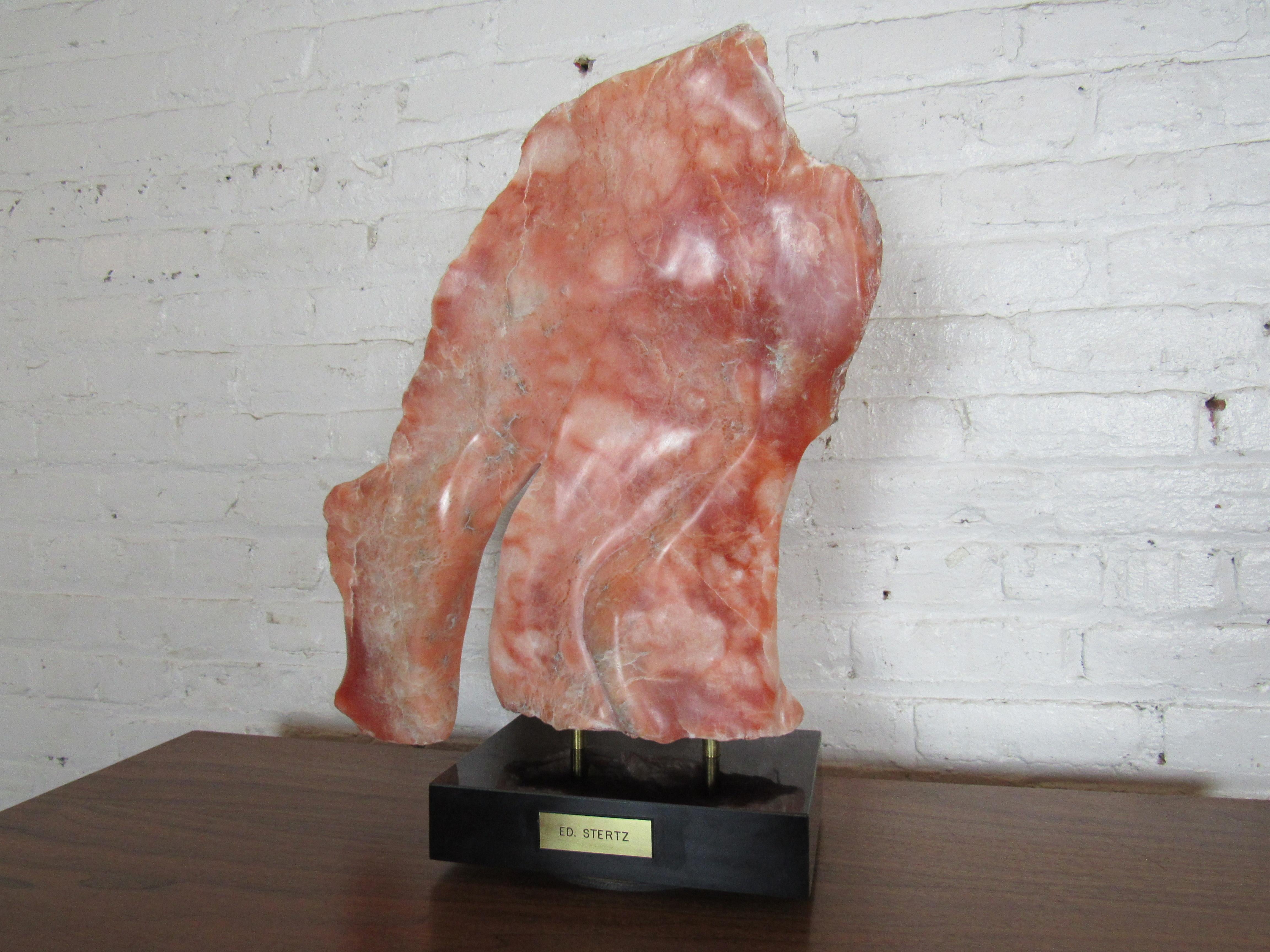 An interesting stone sculpture that is mounted to a swiveling base. The marble's unique form and naturally salmon pink color make for an eye-catching decoration in any room. Please confirm item location with seller (NY/NJ).