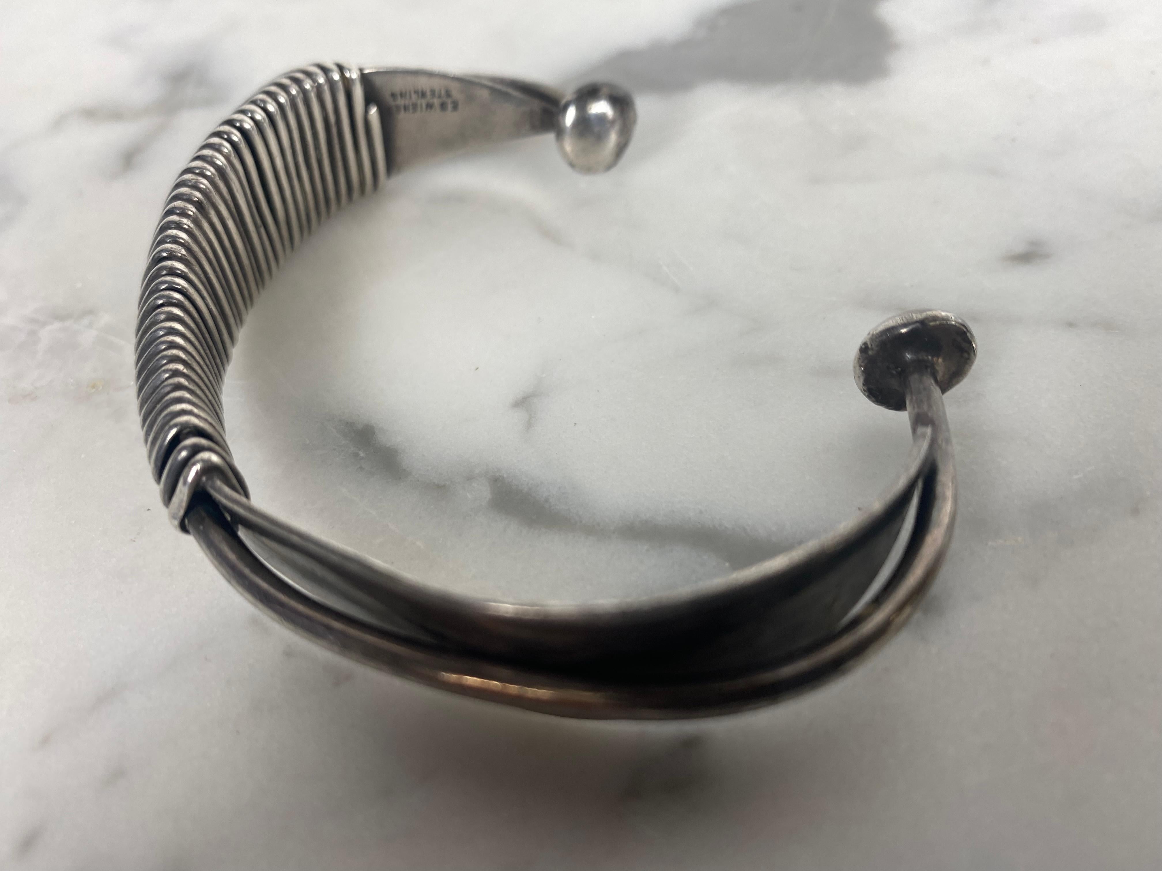This modernist sculptural piece is one of Wiener's first creations as a jeweler-artist, in New York City, circa 1954.This cuff bracelet is composed of two simple aerodynamic pieces with sinuous curved shapes wrapped by an infinite wire, which in