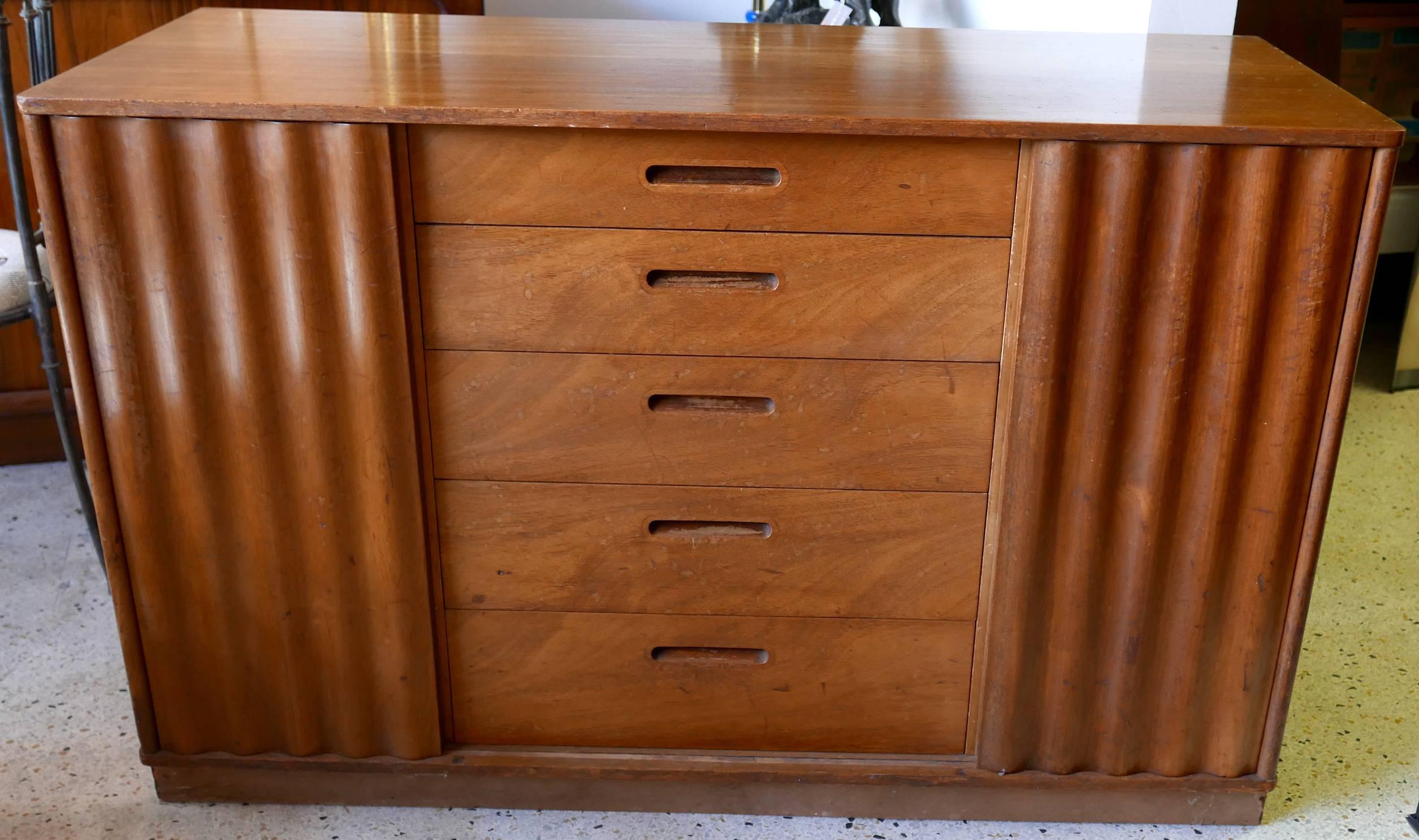 Edward Wormley designed this credenza for Dunbar, circa 1950s. Unique to his design, the sliding accordion front doors can work from the middle, inside out, or from the outside in. A strikingly sophisticated piece of highly-function midcentury