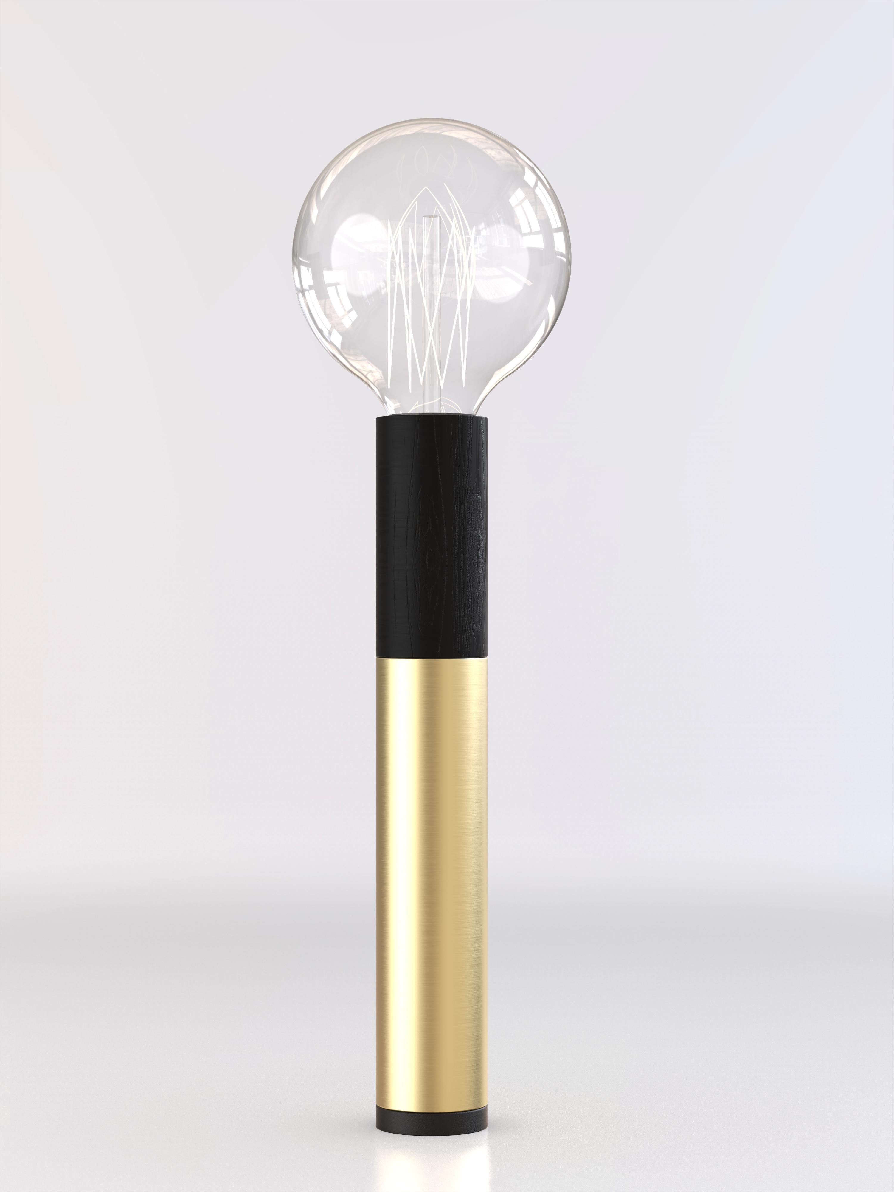Table lamp with brushed brass, black wood and black paint structure.