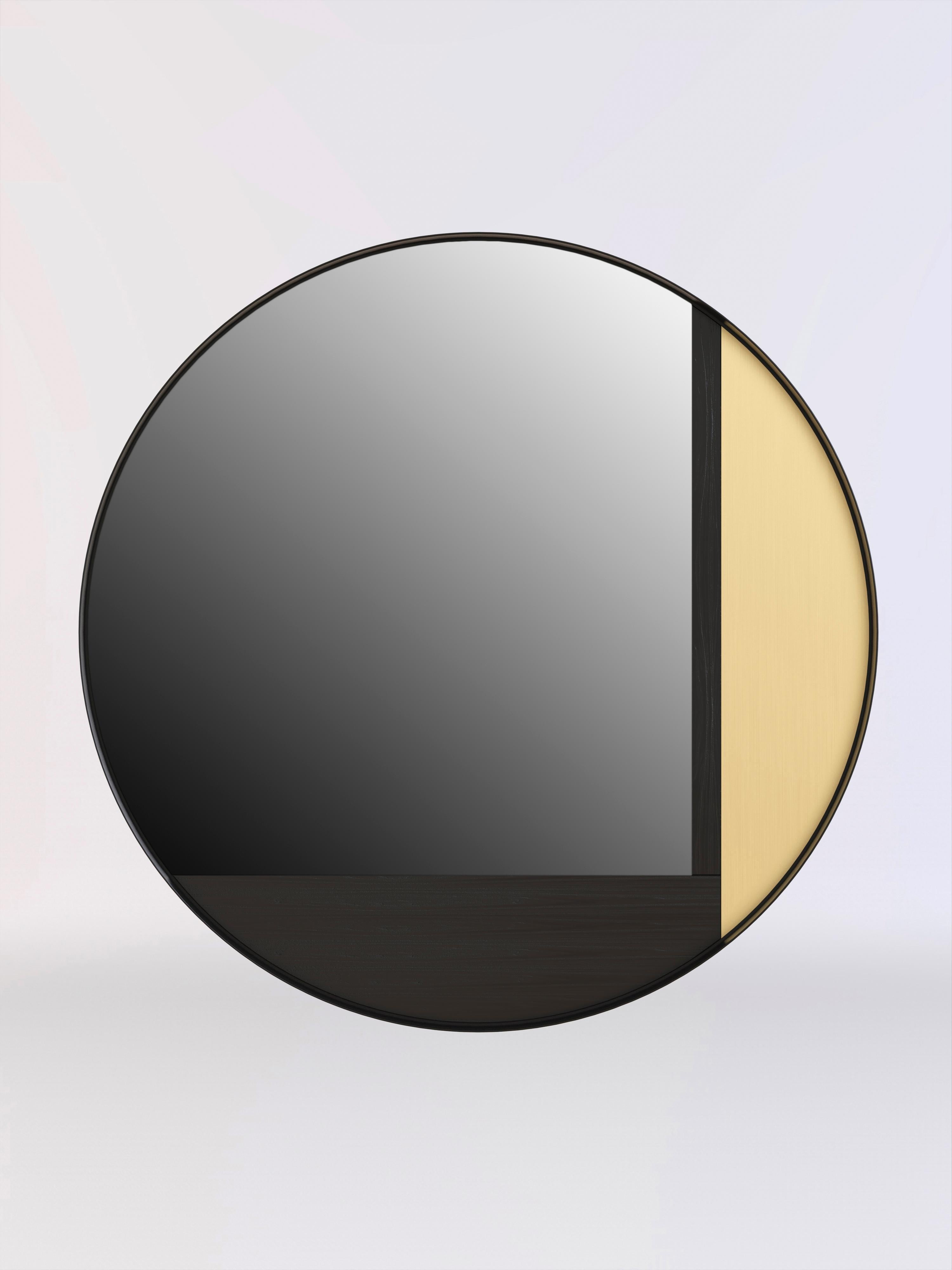 Specchio da parete realizzato in legno nero, ottone spazzolato e struttura in vernice nera.
Lo specchio è dotato di quattro punti di sospensione, che consentono di montarlo in quattro diverse posizioni.
