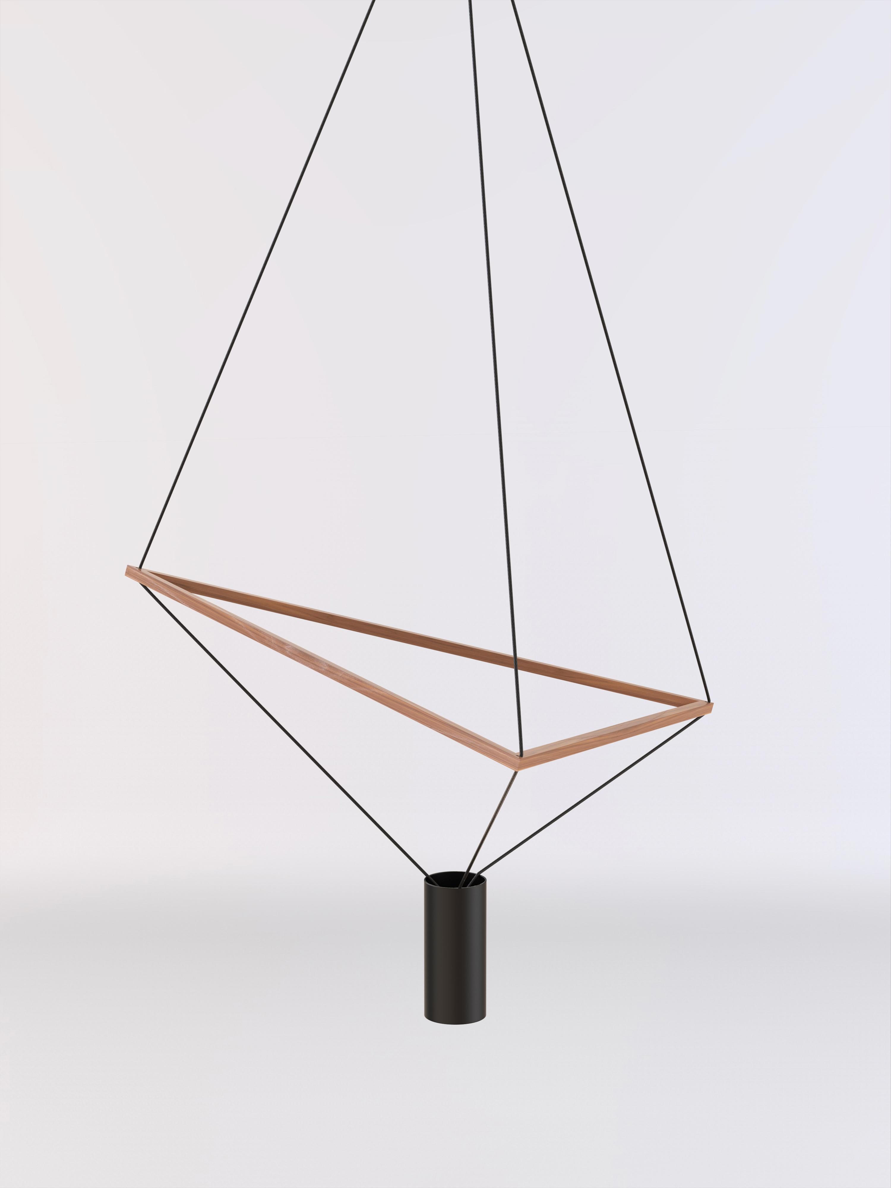 Lampada da soffitto con struttura in legno naturale e paralume in vernice nera.
La struttura triangolare in legno può essere inclinata liberamente, permettendo alla forma della lampada di generare molteplici forme geometriche.
