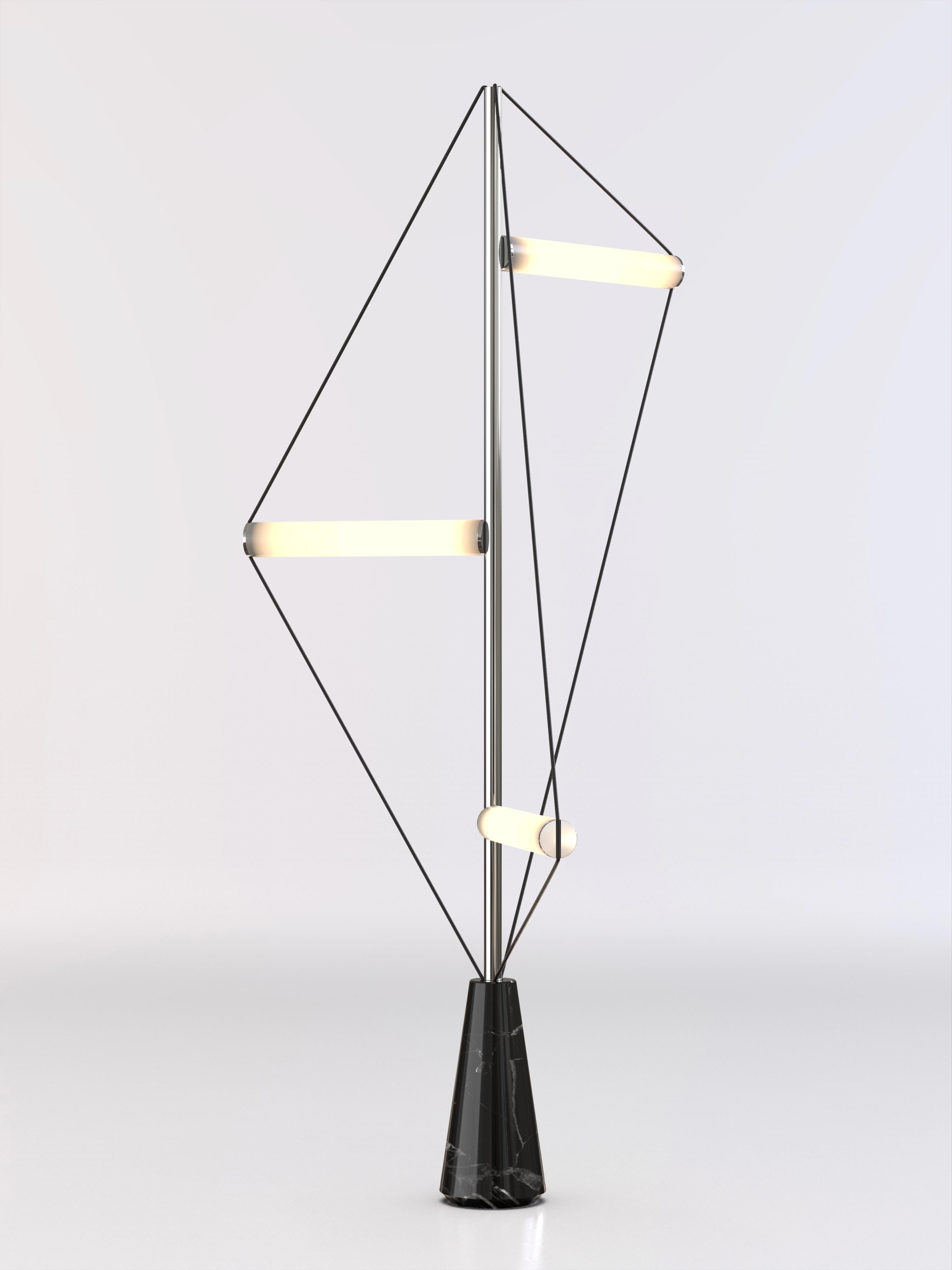 Lampada da terra con base in pietra nera Marquinha, struttura cromata e tubi luminosi smerigliati.