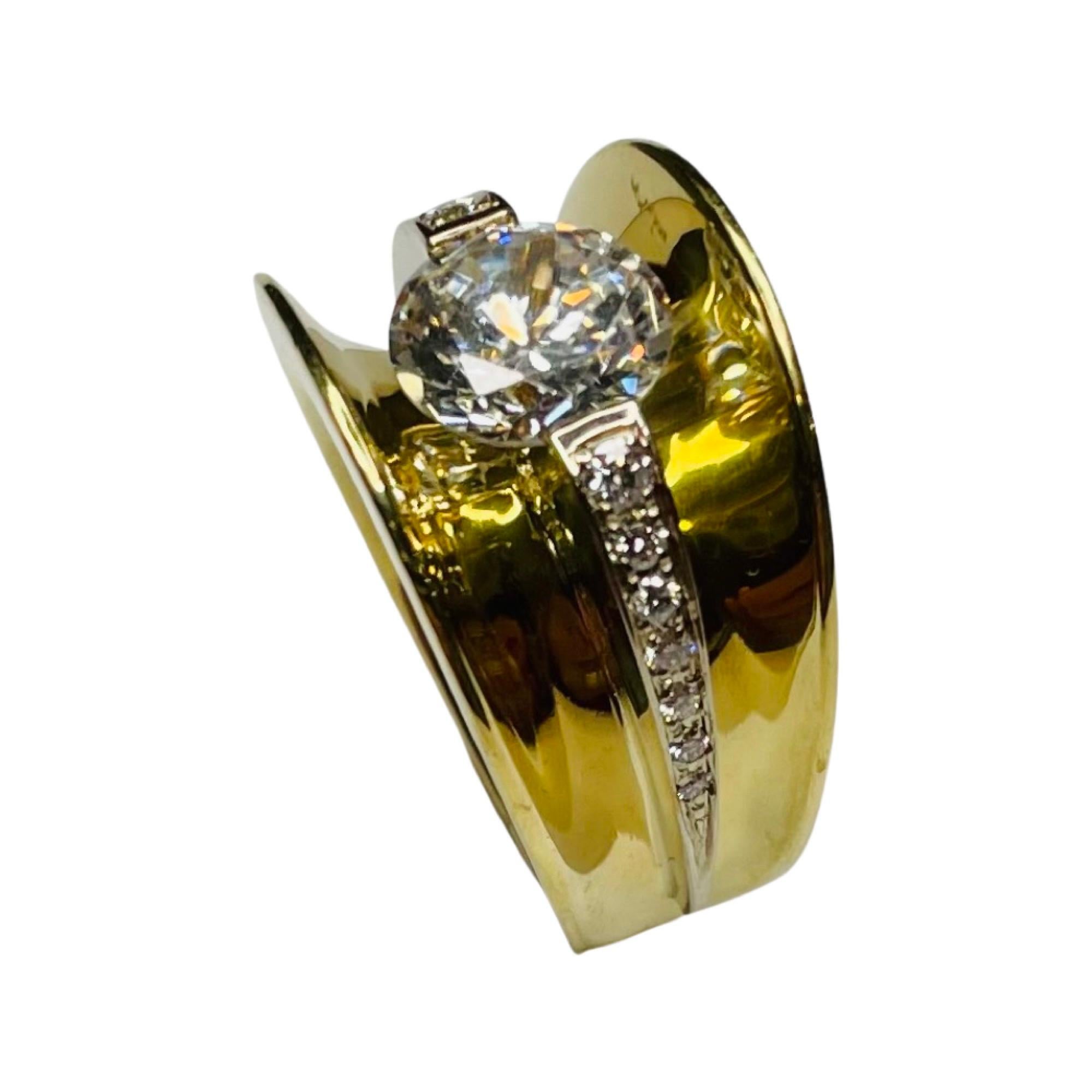 Eddie Sakamoto 18K Yellow and White Gold Diamond Ring. The center stone is a channel set Cubic Zirconia. It is 8.5 mm which is equivalent to a 2.5 carat diamond. It can be replaced with a colored stone, moissonite or natural or synthetic diamond for