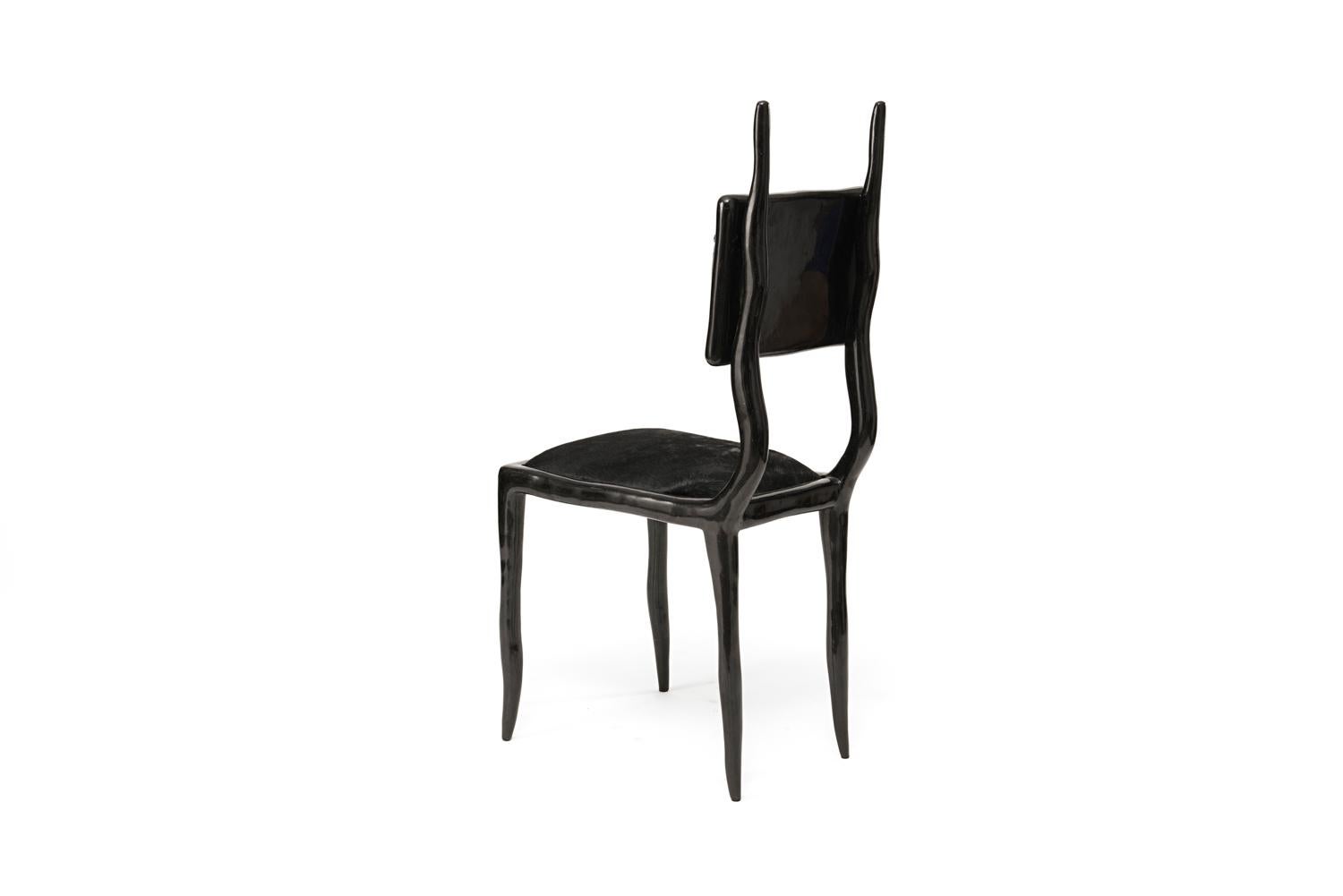 La chaise Eden, en coque de stylo noire et recouverte de cuir de veau noir, apporte l'équilibre parfait entre fantaisie et modernité à n'importe quel espace. Cette chaise peut être utilisée comme pièce d'entrée ou dramatisée autour d'une table de