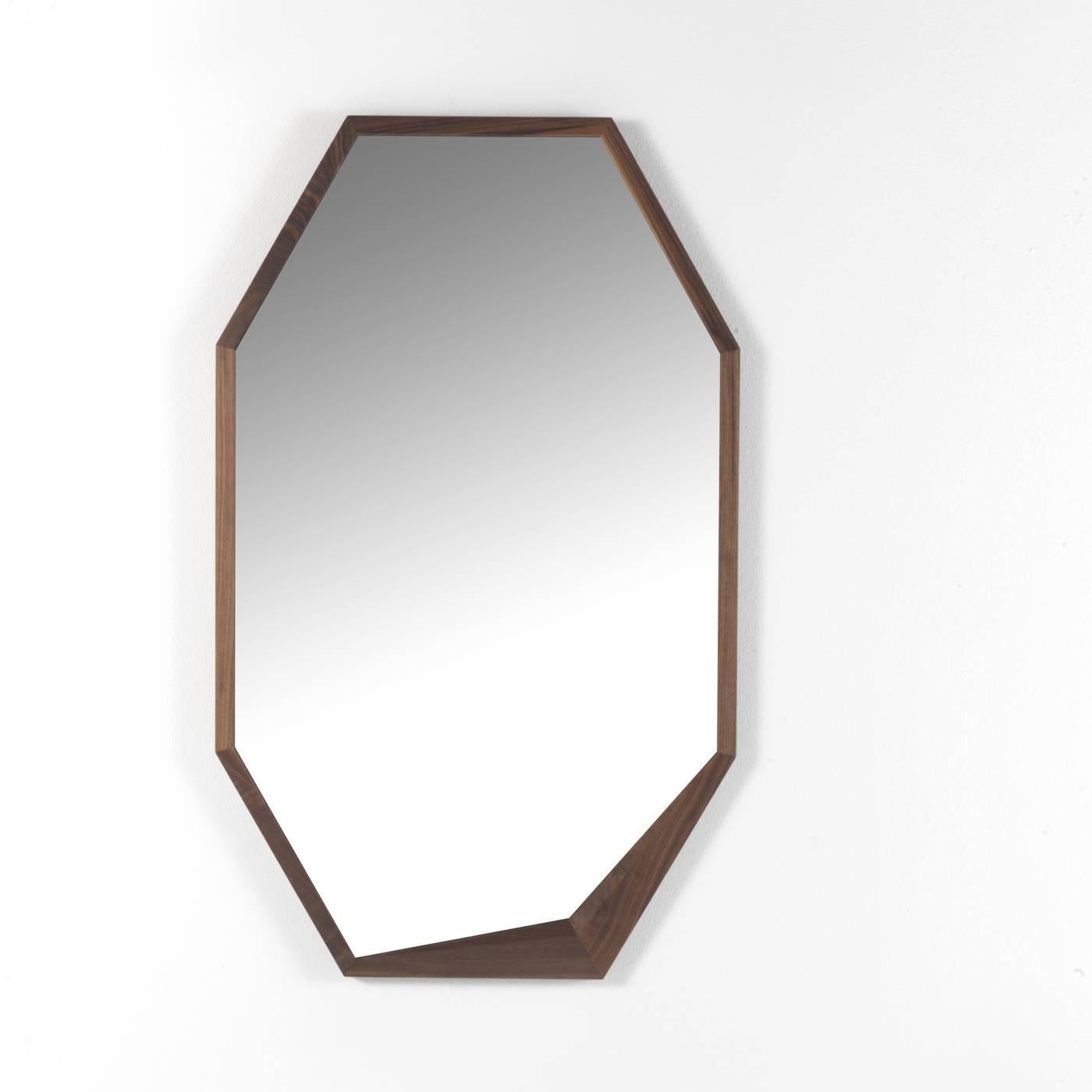 Ce miroir sophistiqué présente une silhouette minimaliste élégante et intemporelle. Son cadre est en noyer Canaletto massif et un charmant détail irrégulier orne l'un des coins de sa forme hexagonale allongée. S'adaptant à tous les décors, ce miroir