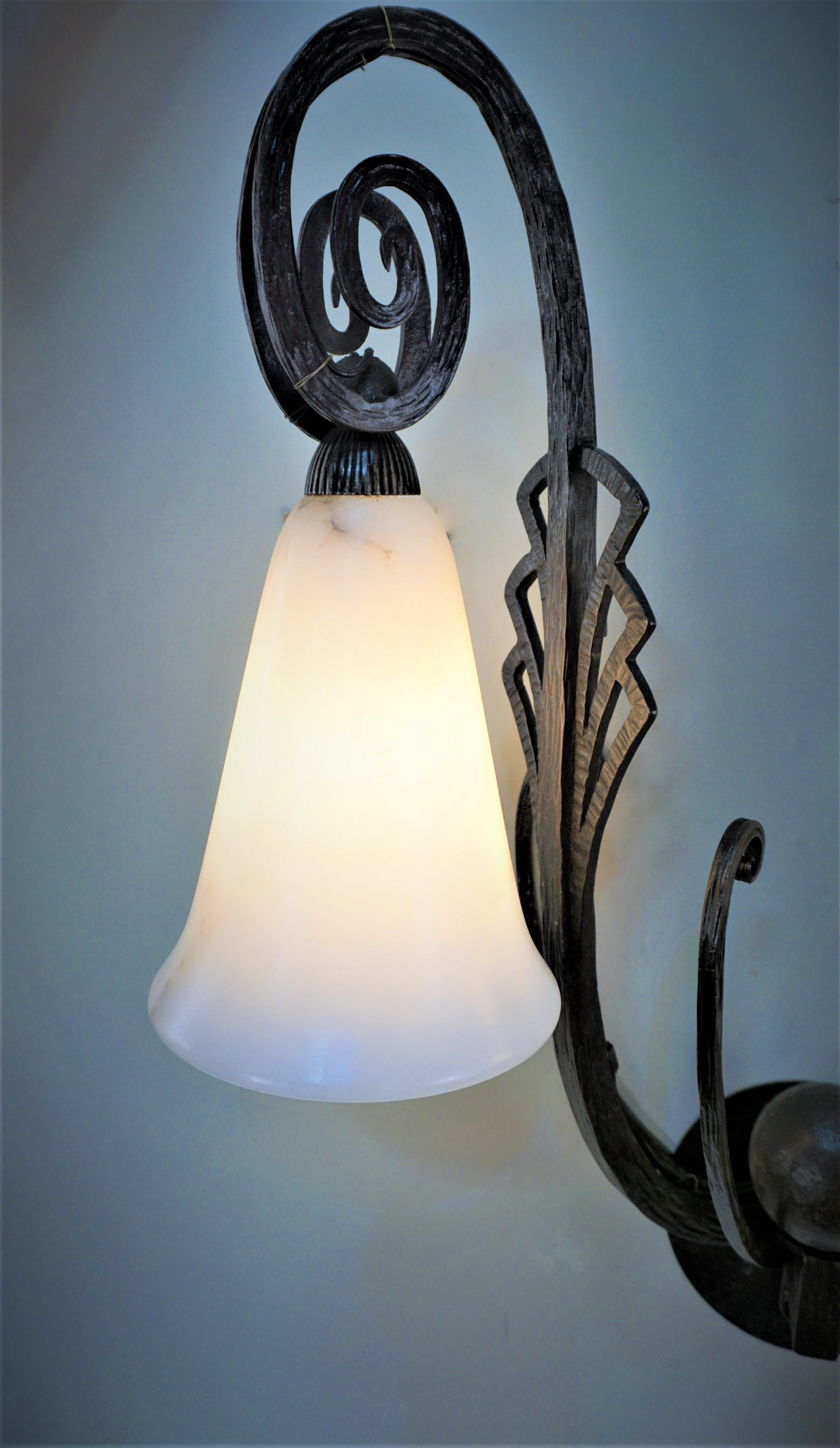 Elegant wrought iron wall sconce with alabaster shades.
Signed Edgar Brandt.