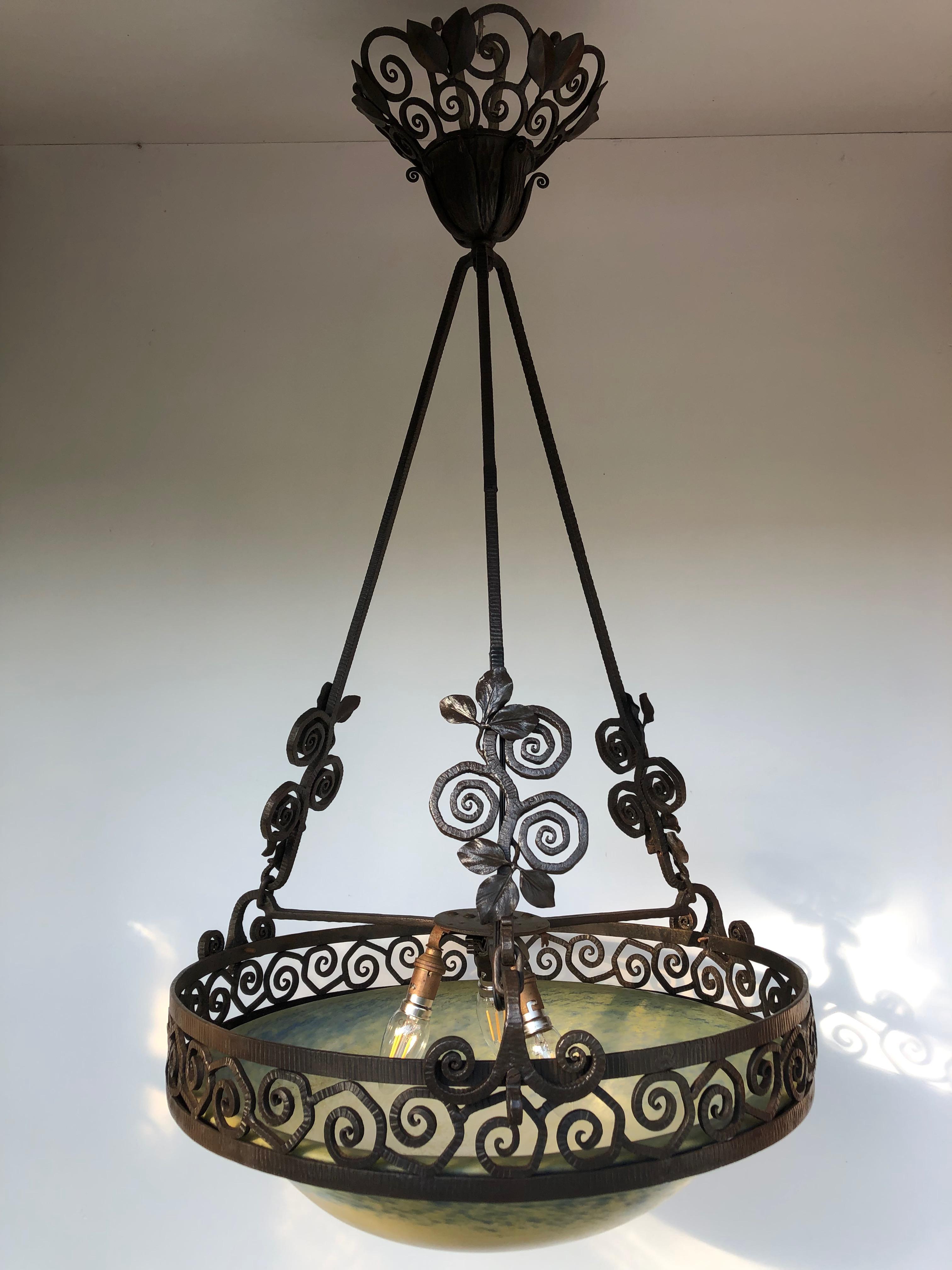 Edgar Brandt and Daum Nancy Art Deco chandelier.

Art deco chandelier circa 1925 in wrought iron decorated with leaves and windings. Frame stamped E. Brandt.
Coupe in blue and cream glass paste signed Daum Nancy.
In perfect condition and