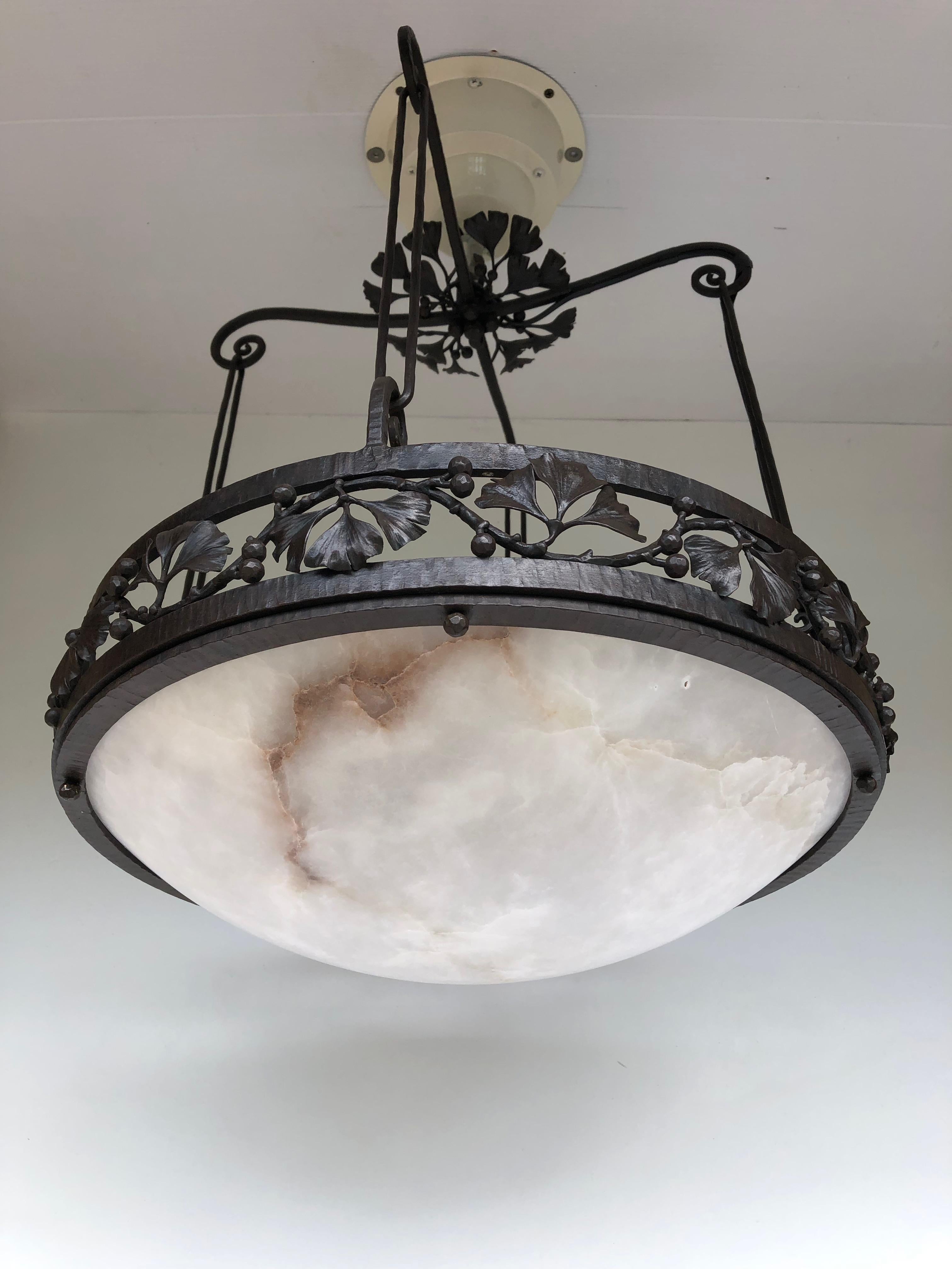 Art deco chandelier circa 1925. 
Wrought iron frame decorated with ginkgo biloba leaves. 
Alabaster basin.
Stamped E. Brandt on the mount.
The chandelier is electrified and in perfect condition.
Height: 55cm
Diameter: 45cm
Weight: 10kg

You