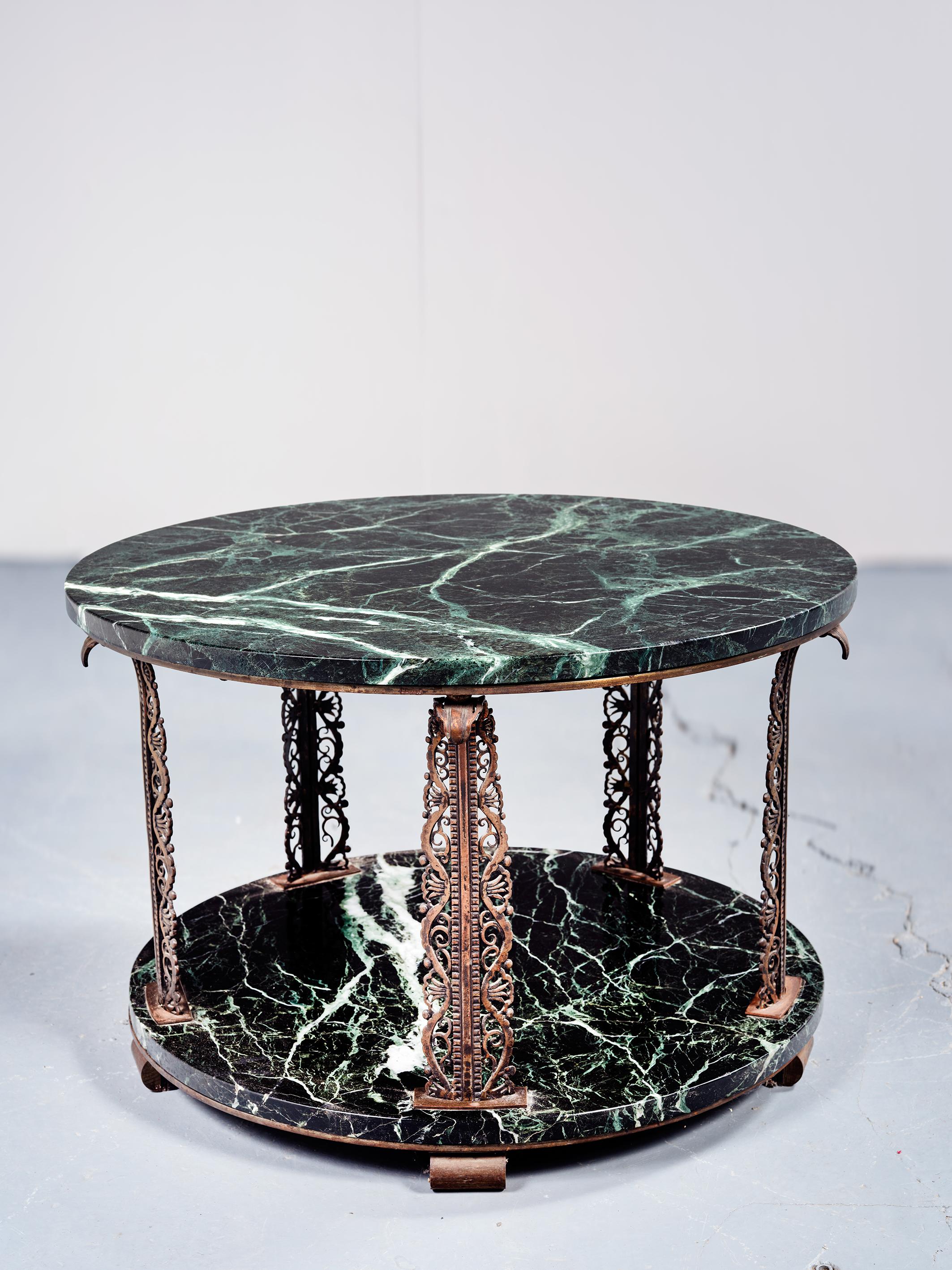 Edgar Brandt (1880-1960)
Four-legged wrought iron coffee table,
decorated with scrolls and geometric shapes,
two tops in “Vert de Mer” marble.
Stamped E. BRANDT.
Circa 1925
H: 45 cm; D: 70 cm