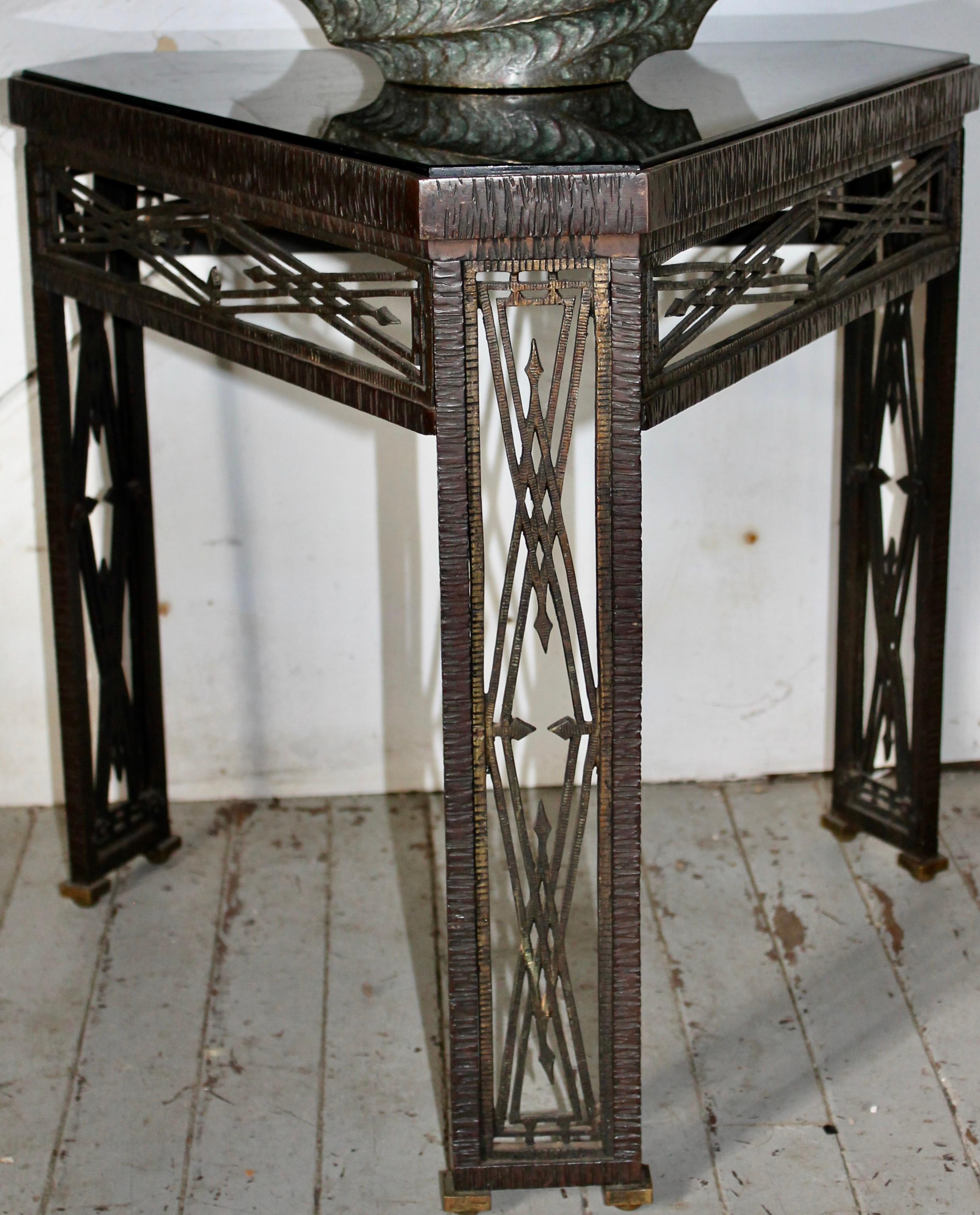 De la máxima calidad. Pequeña mesa triangular art déco forjada a mano, de hierro y bronce, con tablero de cristal negro. El fabricante más probable es Edgar Brandt, tanto un  Taller francés y americano. Calcografía numerada en tres lugares:
2028.