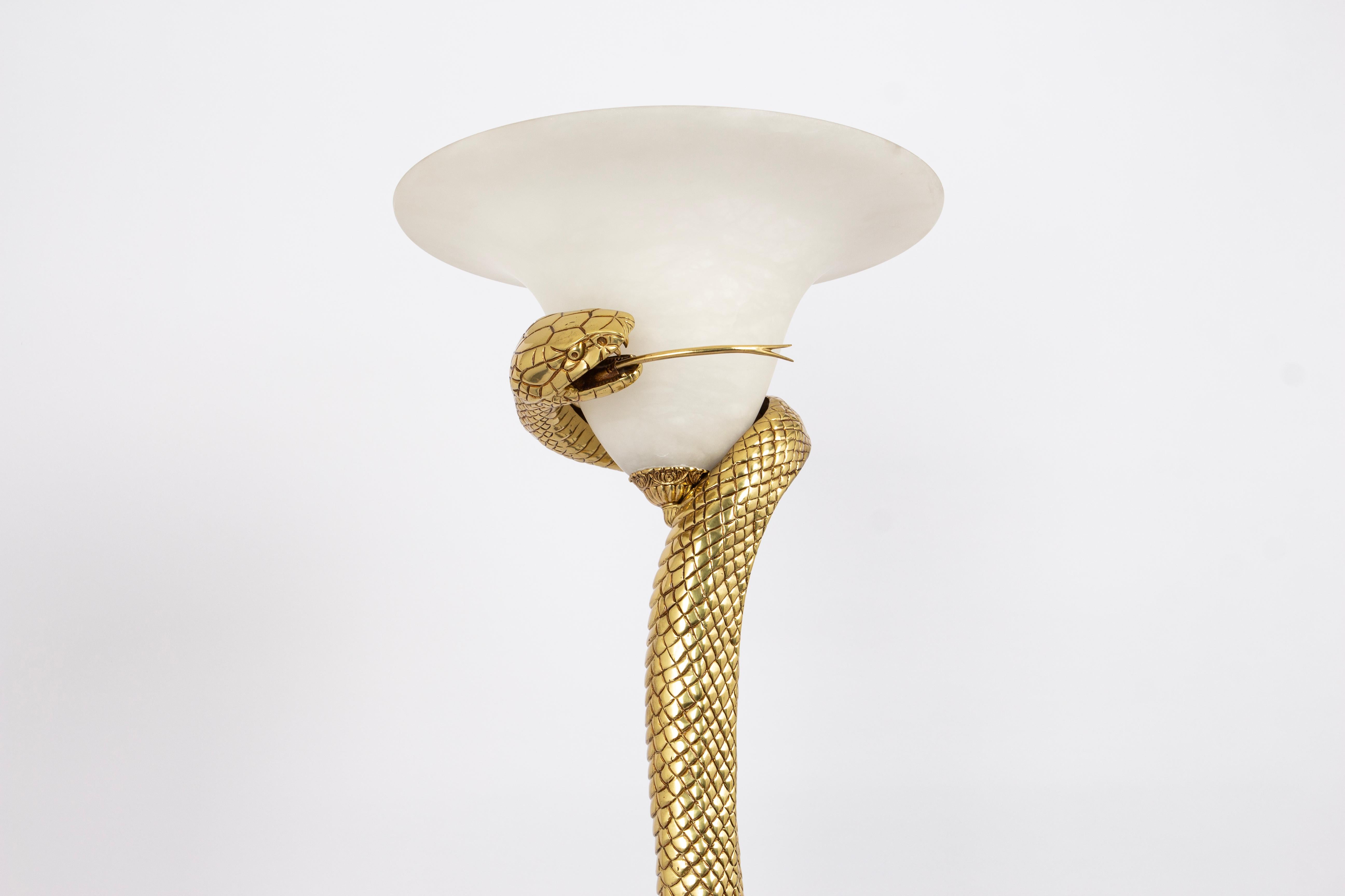 Questa lampada, che ricalca l'originale lampada a forma di serpente di Edgar Brandt, è realizzata in bronzo fuso a mano. Il pezzo mostra un serpente molto dettagliato, arrotolato intorno a un'ombra chiara con la bocca aperta che espone le zanne e la