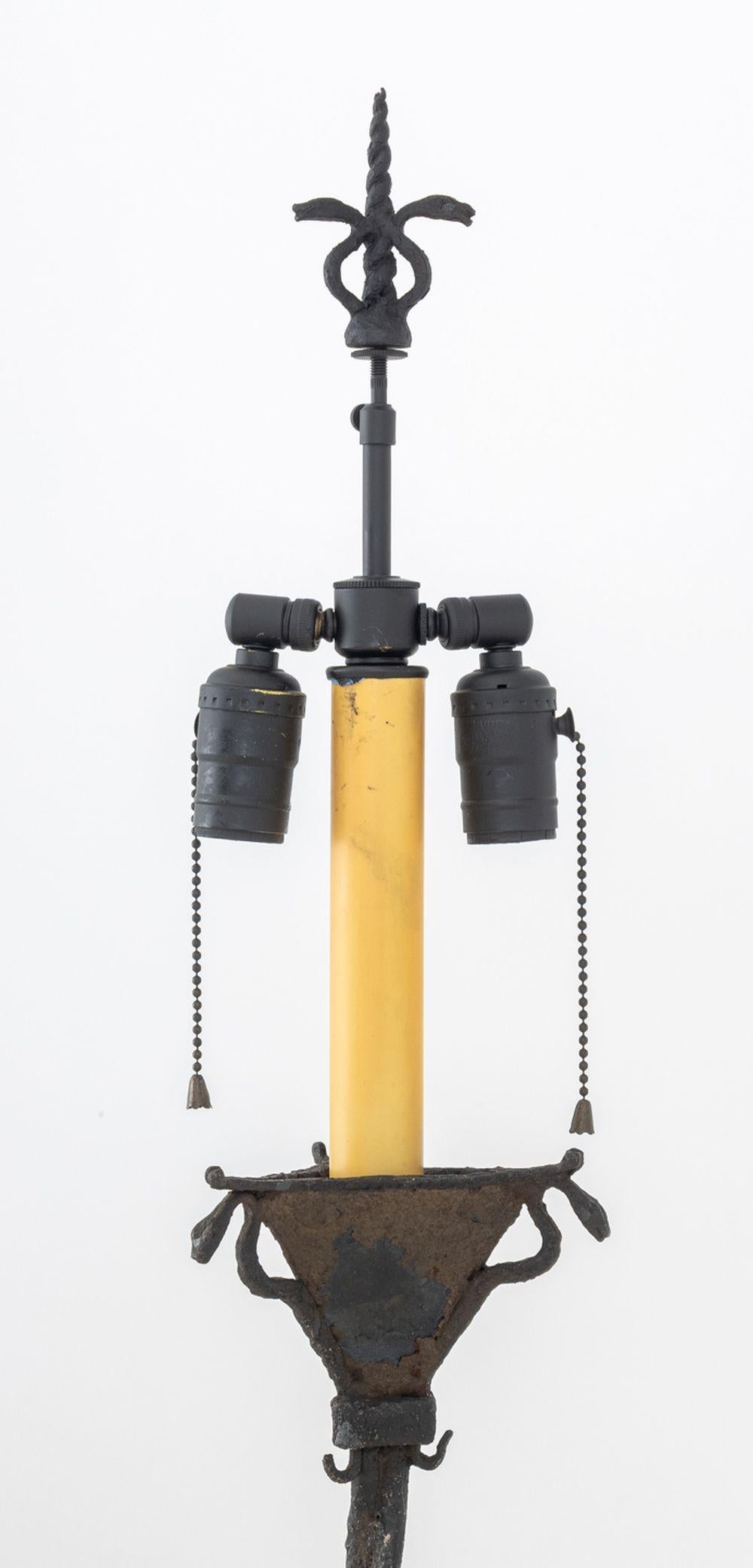 Lampadaire en fer forgé patiné de style Edgar Brandt, avec fleuron à tête de serpent et corne de licorne et motif à tête de serpent sur un support en forme de torsade et une base tripode. 69