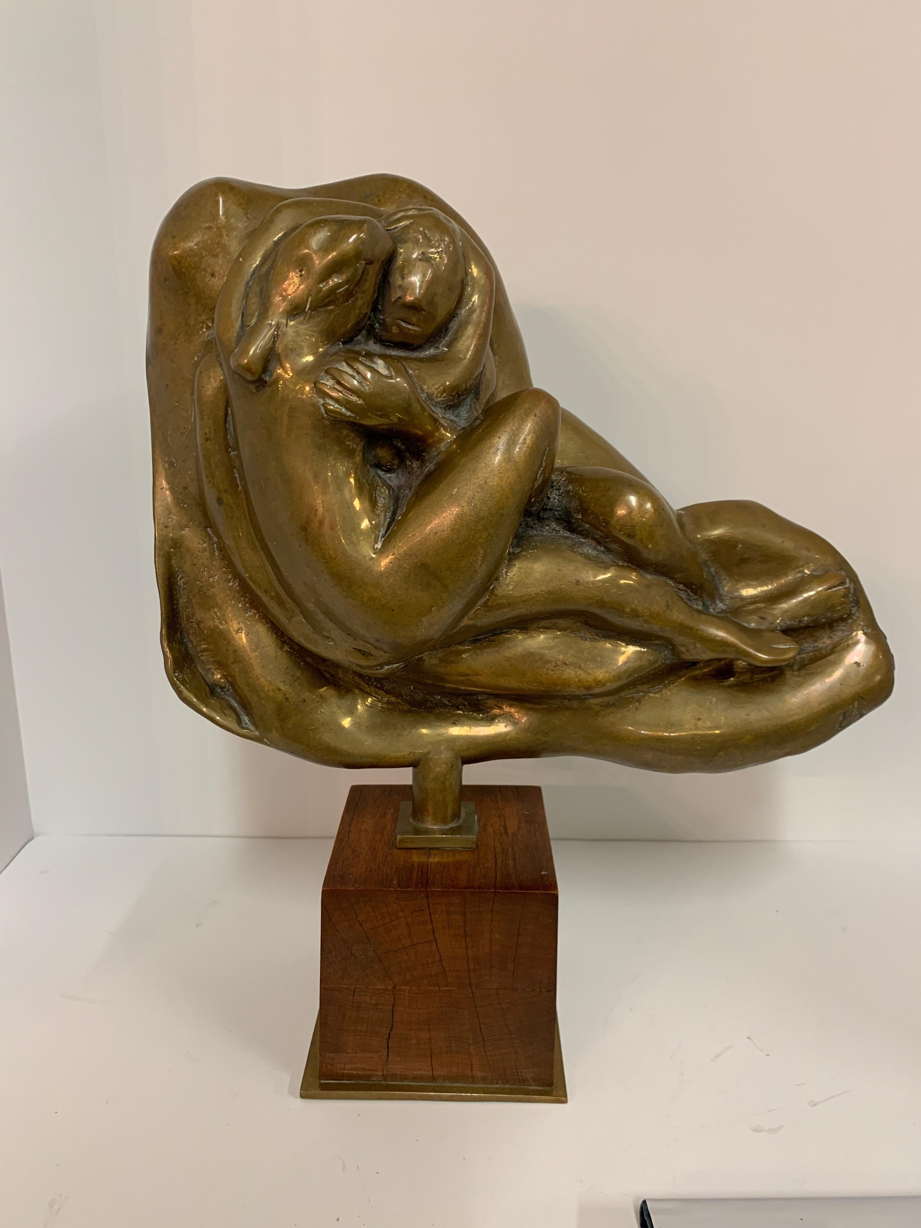 A bronze by the noted artist Edgar Britton (American, 1901-1982, Illinois, Colorado, Nebraska). This piece shows a couple in an embrace. The piece is signed EB on front on the back 1/3 and the initials AWF. The wood base has cracks and marks. The