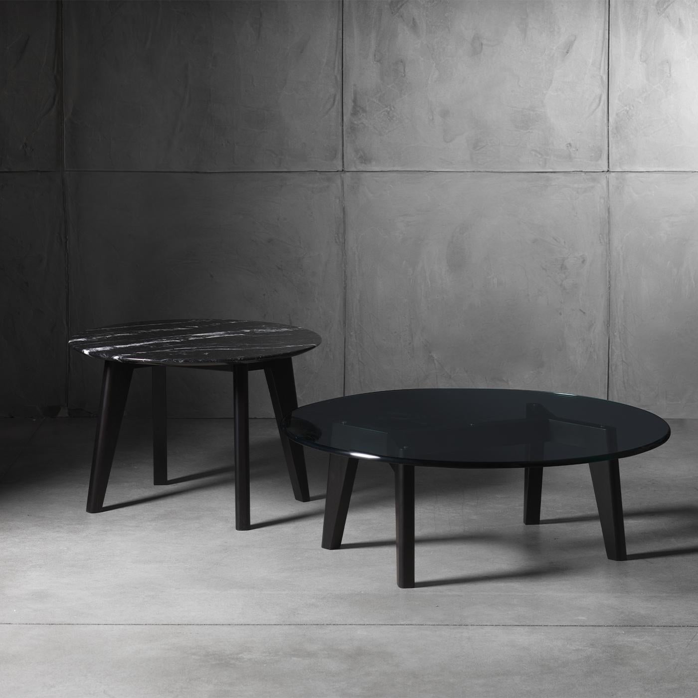 Made from a black, wooden base with a Nero Marquina marble top, this coffee table adds a striking touch to any environment. Bold yet minimal, the veining of the marble adds a dramatic pop of contrasting white. As the veining of each piece of marble