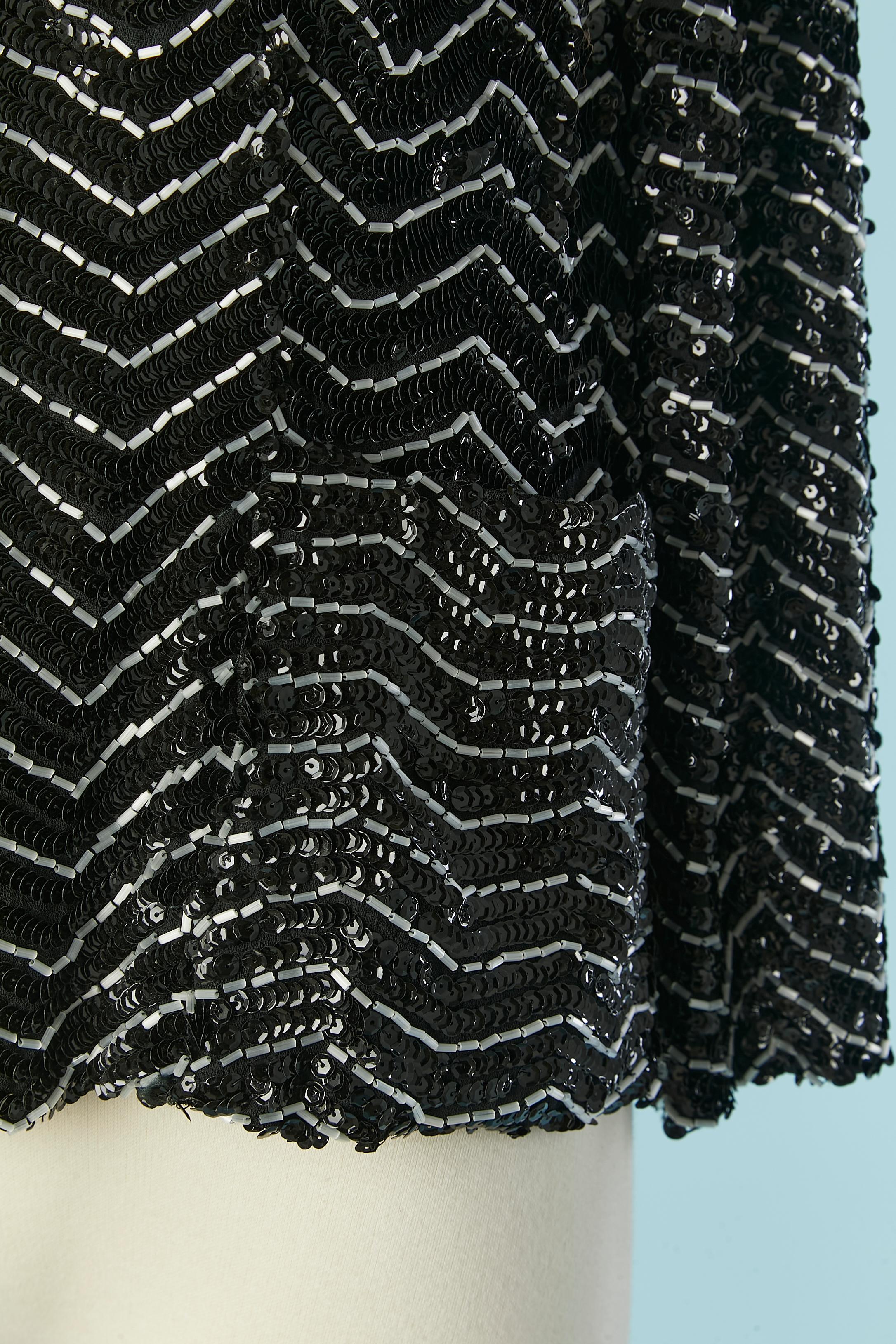 Veste de soirée bord à bord avec des perles de verre blanches et des paillettes noires ;
Pad d'épaule. Doublure en crêpe noir. Poches sur les deux côtés.
TAILLE M 
