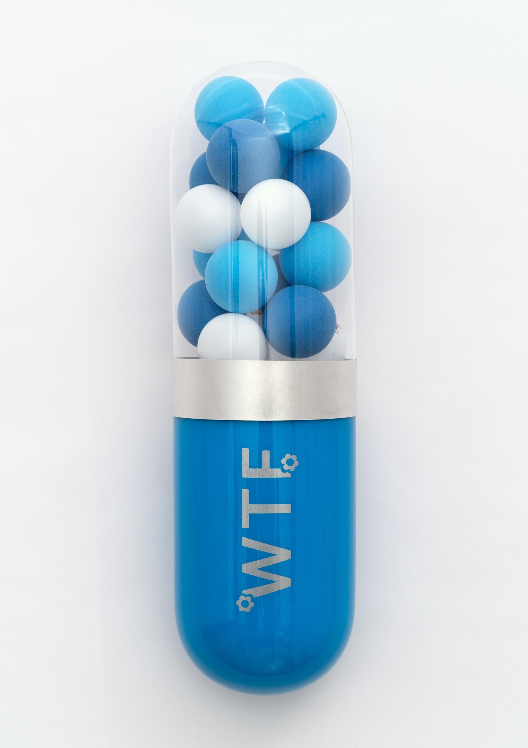 "WTF" - Limited edition blue glass pill sculpture by Edie Nadelhaft. Edition of 9. 

Signed and numbered on the back by the artist.

The piece is equipped with a D-ring on the back for easy hanging.

"WTF" is part of Edie Nadelhaft's "Better Living