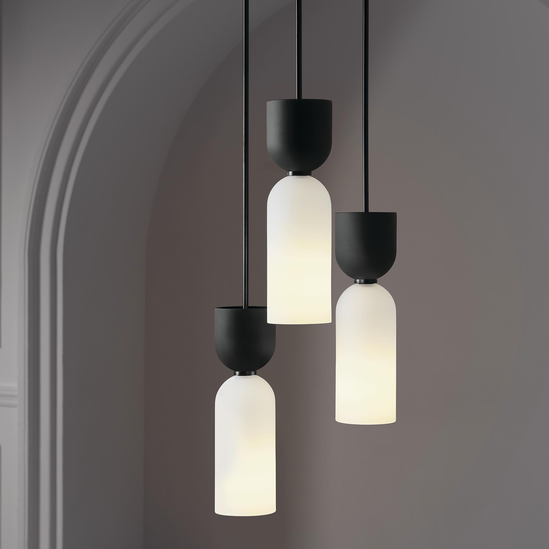 The Edie Pendant pairs two similar forms in hand-blown glass.

Pure shapes, geometry, rhythm and repetition create a harmonious whole when used in multiple, or a streamlined statement when used solo. A contrasting black-and-white color scheme