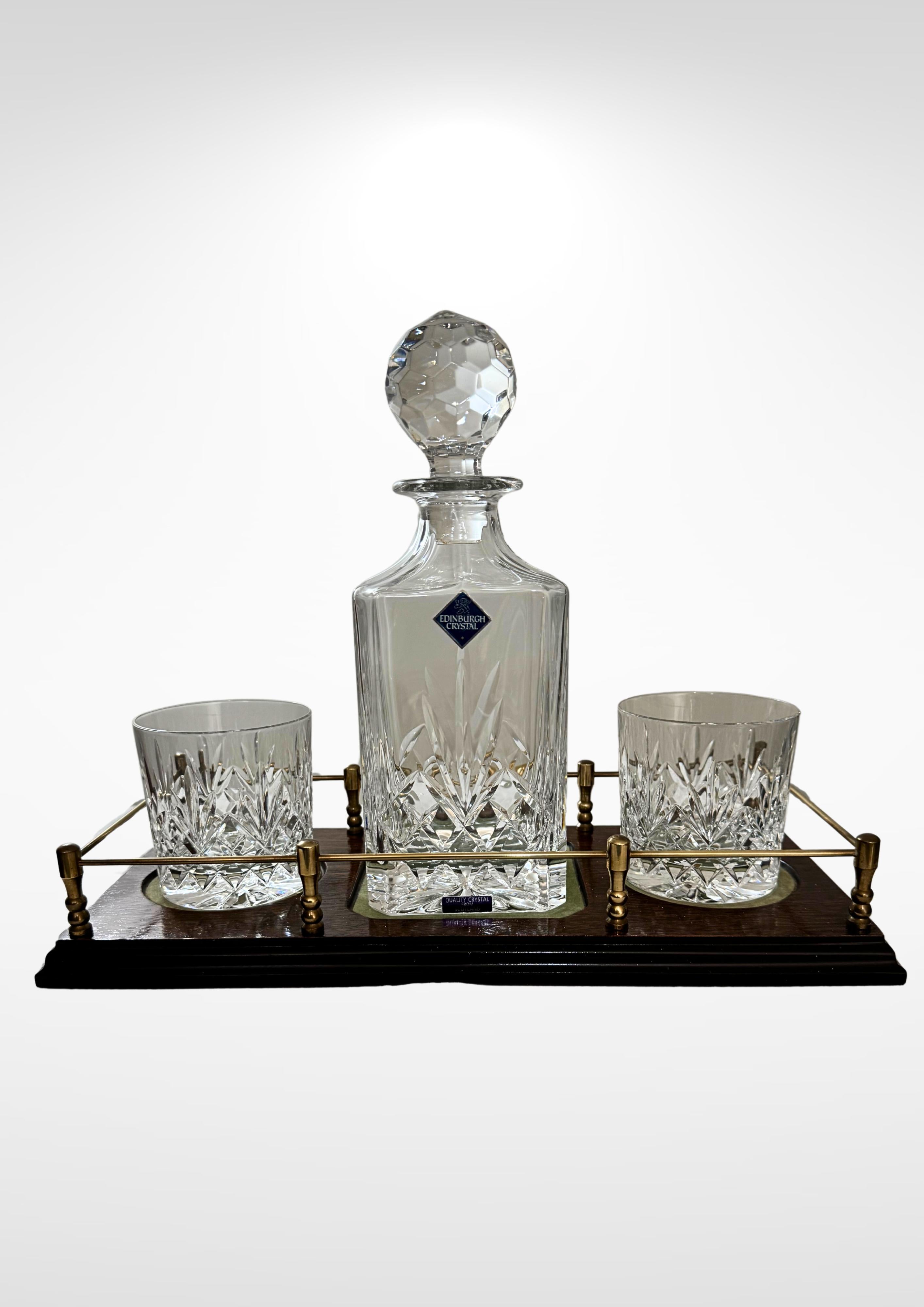 Edinburgh crystal glass decanter, whiskey tumblers and trays set.
Consists of one 75cl stoppered decanter, 2 fairly large sized matching whiskey tumblers and one wooden salver tray with brass galleried edge.
All in impeccable condition and showing