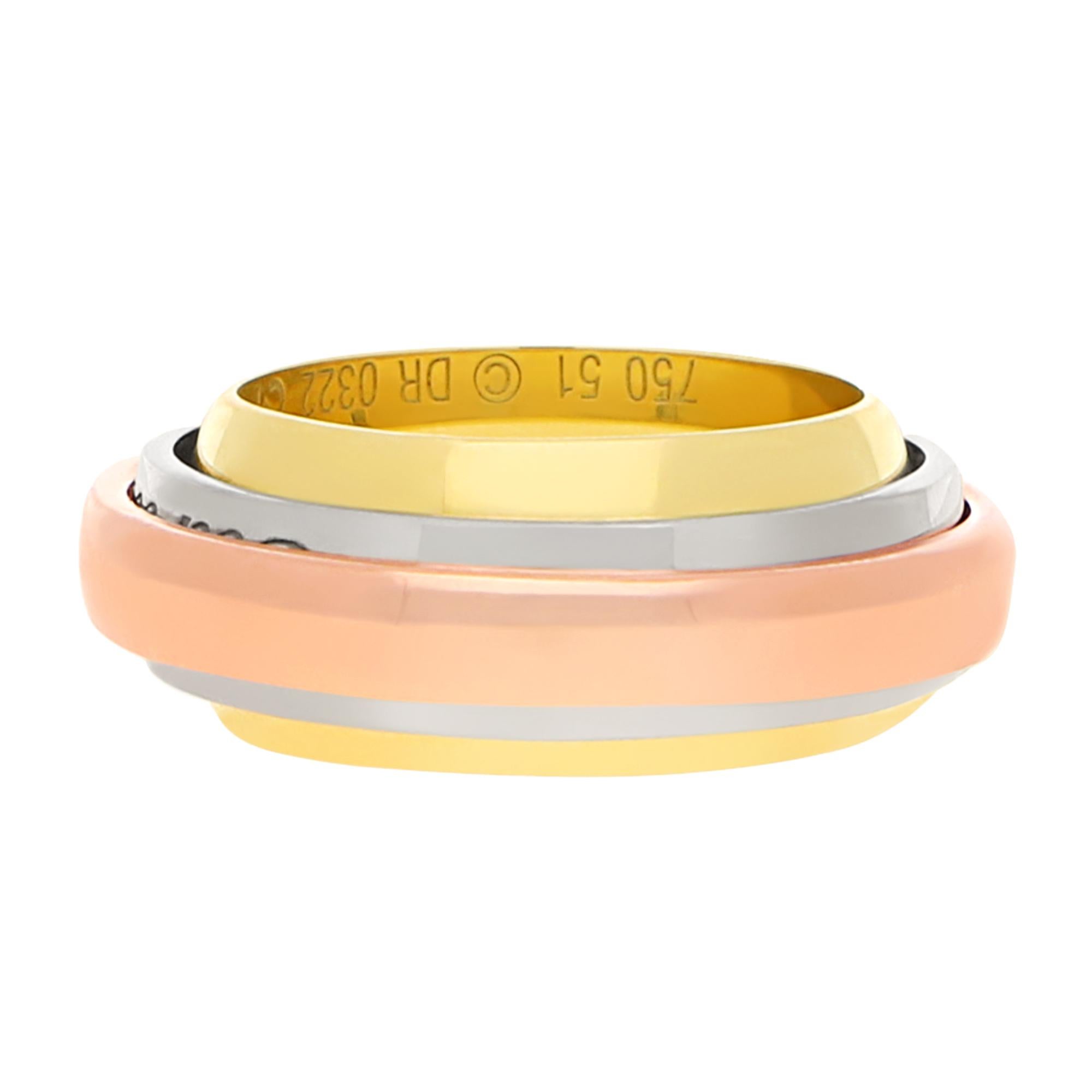 A limited edition Le Must de Cartier Essence trinity ring set in 18k multicolored gold.
  
This unique trinity ring is from a limited Cartier collection which was launched in 2002. It is designed with a wider inner yellow gold band, layered with