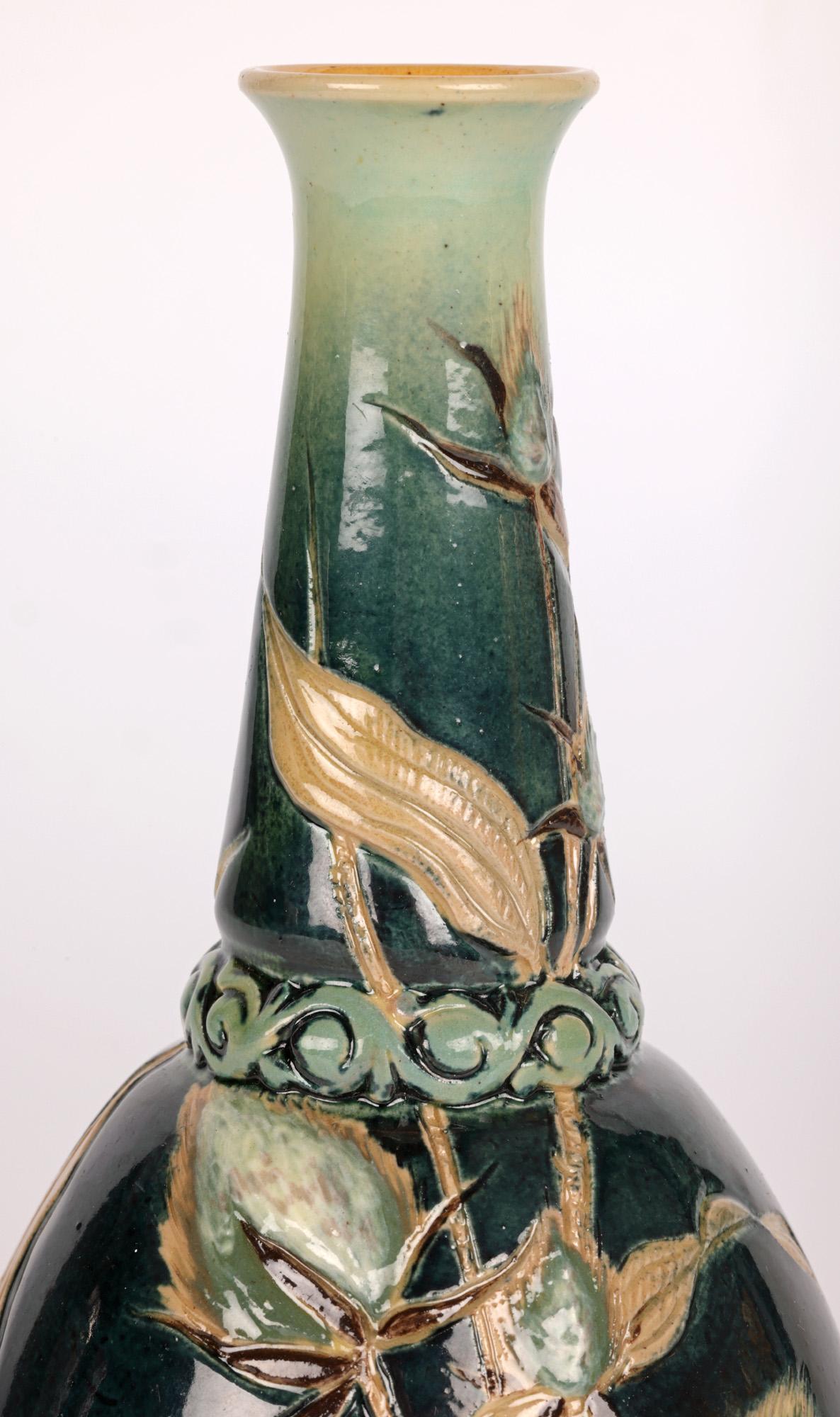 Un insolito e straordinario vaso di Doulton Lambeth Silicon Ware decorato con disegni di cardo incisi e pate-sur-pate dalla famosa artista Edith D. Lupton e datato 1885. Il vaso in gres è a forma di bottiglia e poggia su un piede stretto e