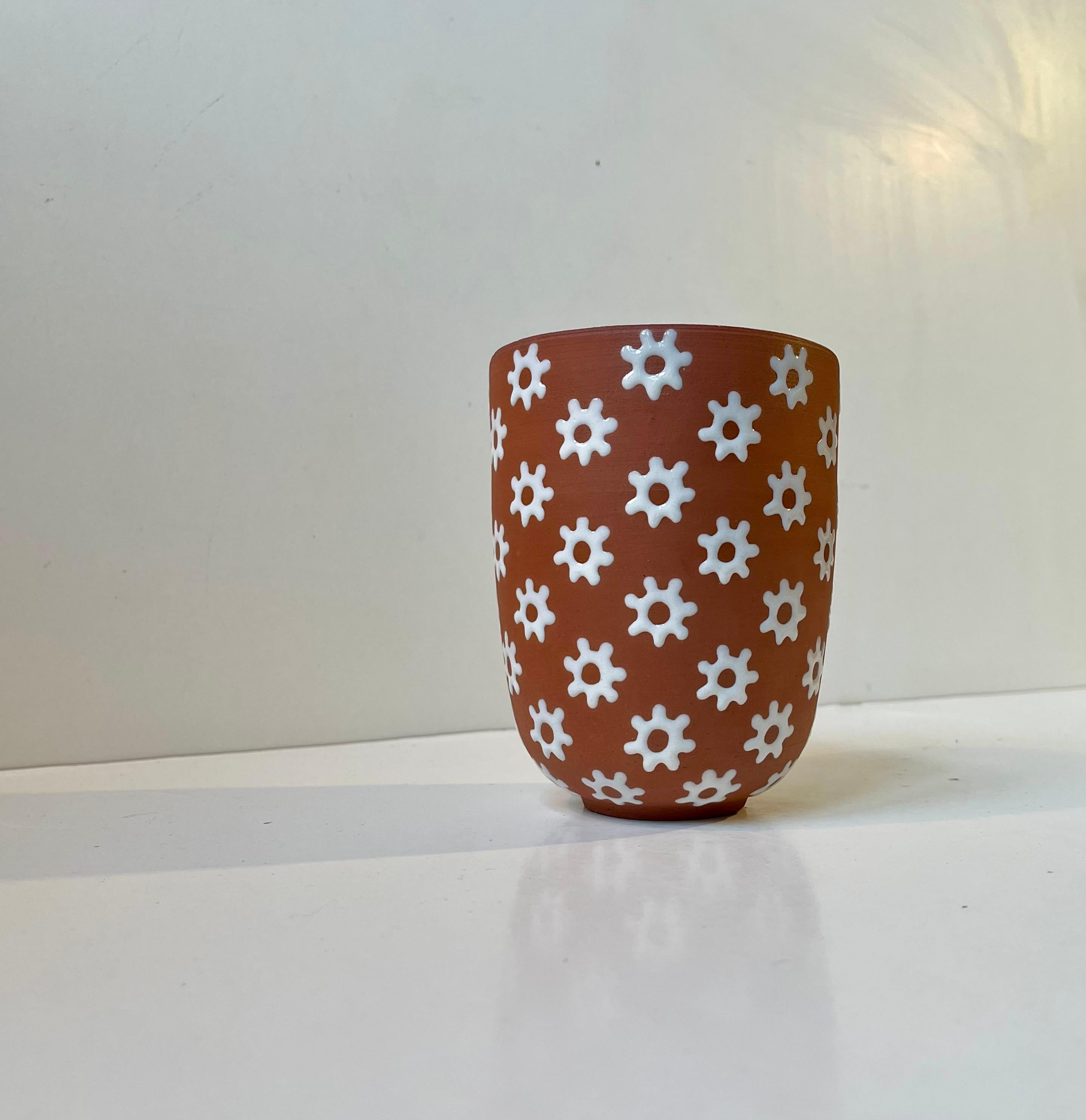 Vase Signature Design von Edith Nielsen - Zeuthen Dänemark um 1950. Körper aus rotem Ton, verziert mit weißen Blumen. Das Innere dieses Stücks hat die gleiche weiße Glasur. 

Abmessungen: H: 13,5 cm, Durchmesser: 10 cm (oben).
