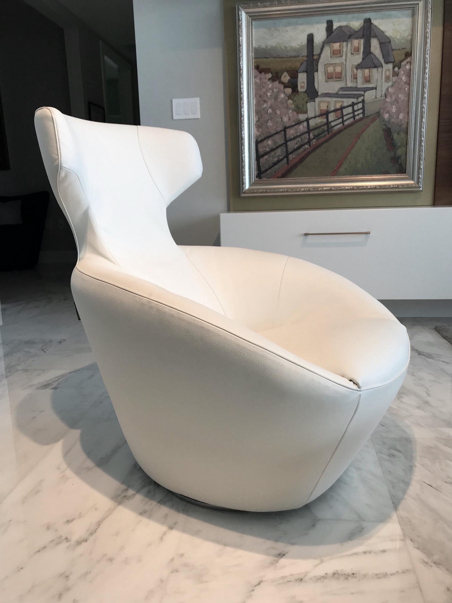 Ultra-luxury lounge chair in custom luxury white leather. From the Edito series designed by Sacha Lakic for Roche Bobois. Chair has Mid-Century Modern inspired form reminiscent of Space Age designs. Features pivoting swivel base design with auto