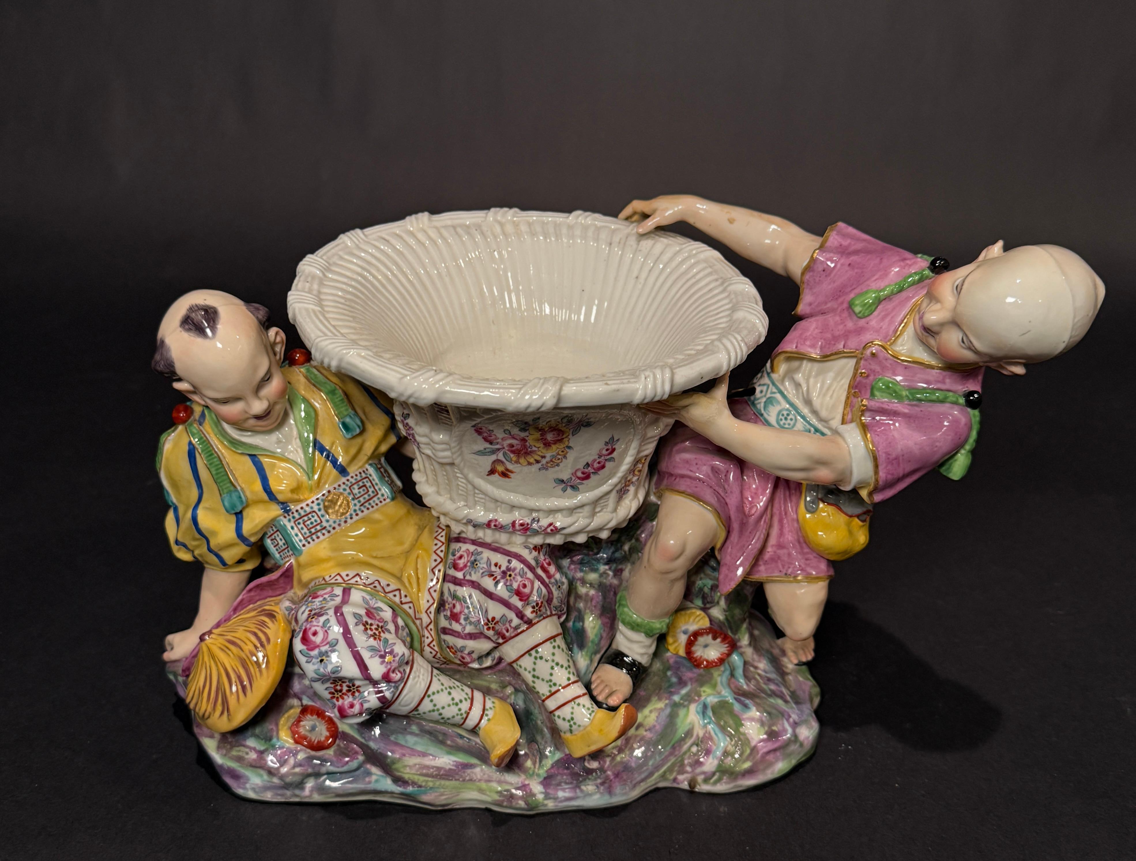 Edme Samson et Cie (French, 1845-1969), late 19th century. Large figural Mennecy-style polychrome porcelain chinoiserie jardiniere modeled as two figures holding a basket form decorated with painted flowers. Marked 