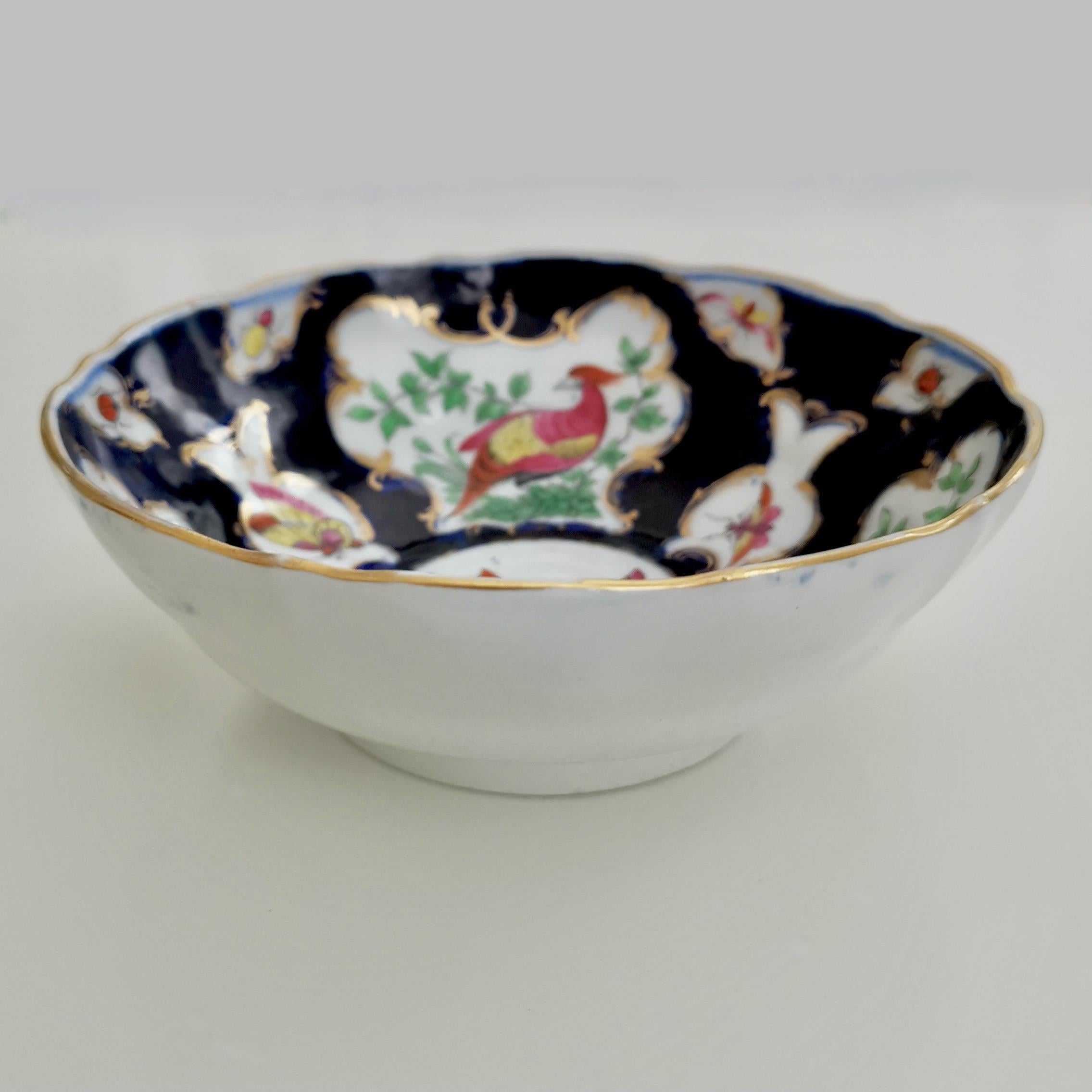 This is a beautiful small bowl made by Edmé Samson in Paris some time in the 19th Century. The bowl is in the 'blue scale' style that the Worcester factory made in the 18th century, and carries a fake Worcester fret mark.
 
This bowl might in fact