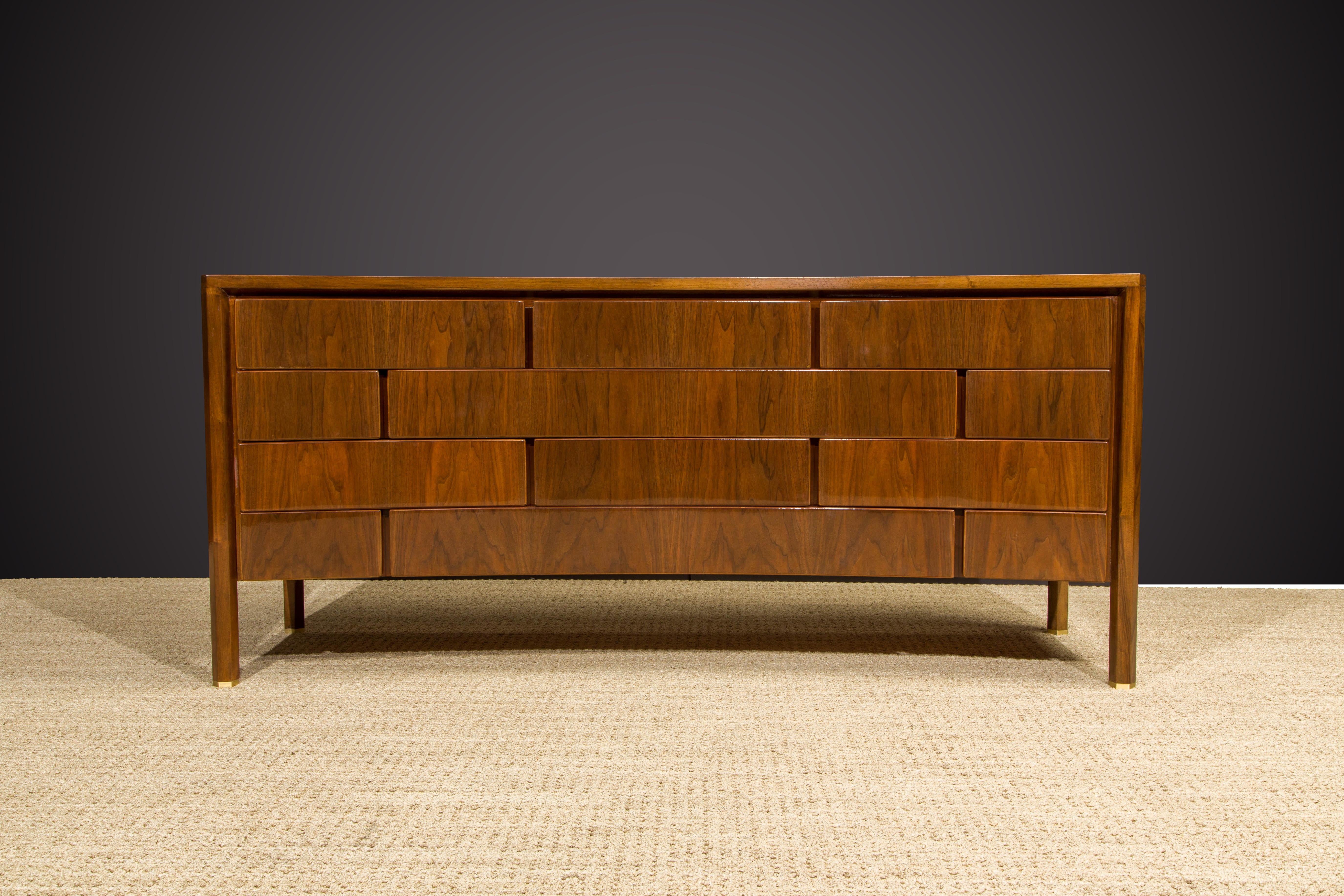 This impressive twelve-drawer dresser in walnut was designed by Edmond J. Spence and made in Sweden in the late 1950s to early 1960s. We just completed refinishing it with an expensive French Polish, the most laborious finish available due to its