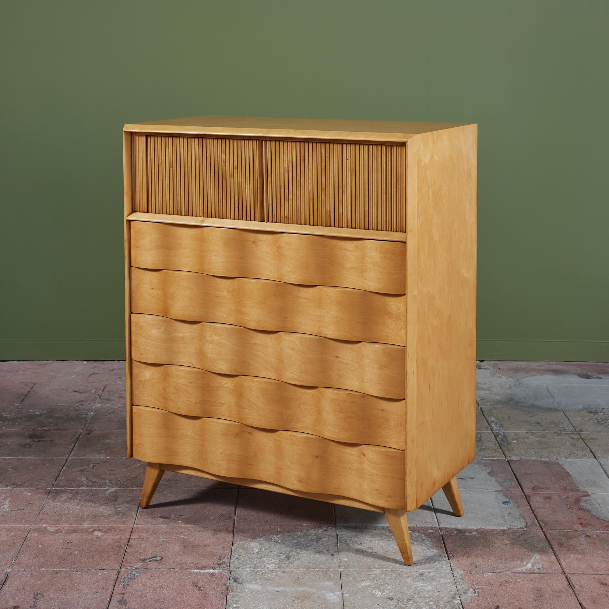 Tall dresser by Edmond Spence, c.1950s, Sweden. The maple dresser features five drawers with a unique sculpted wave front design. The top of the dresser has two tambour doors that open to reveal a divided shelf. The dresser rests on 4 splayed
