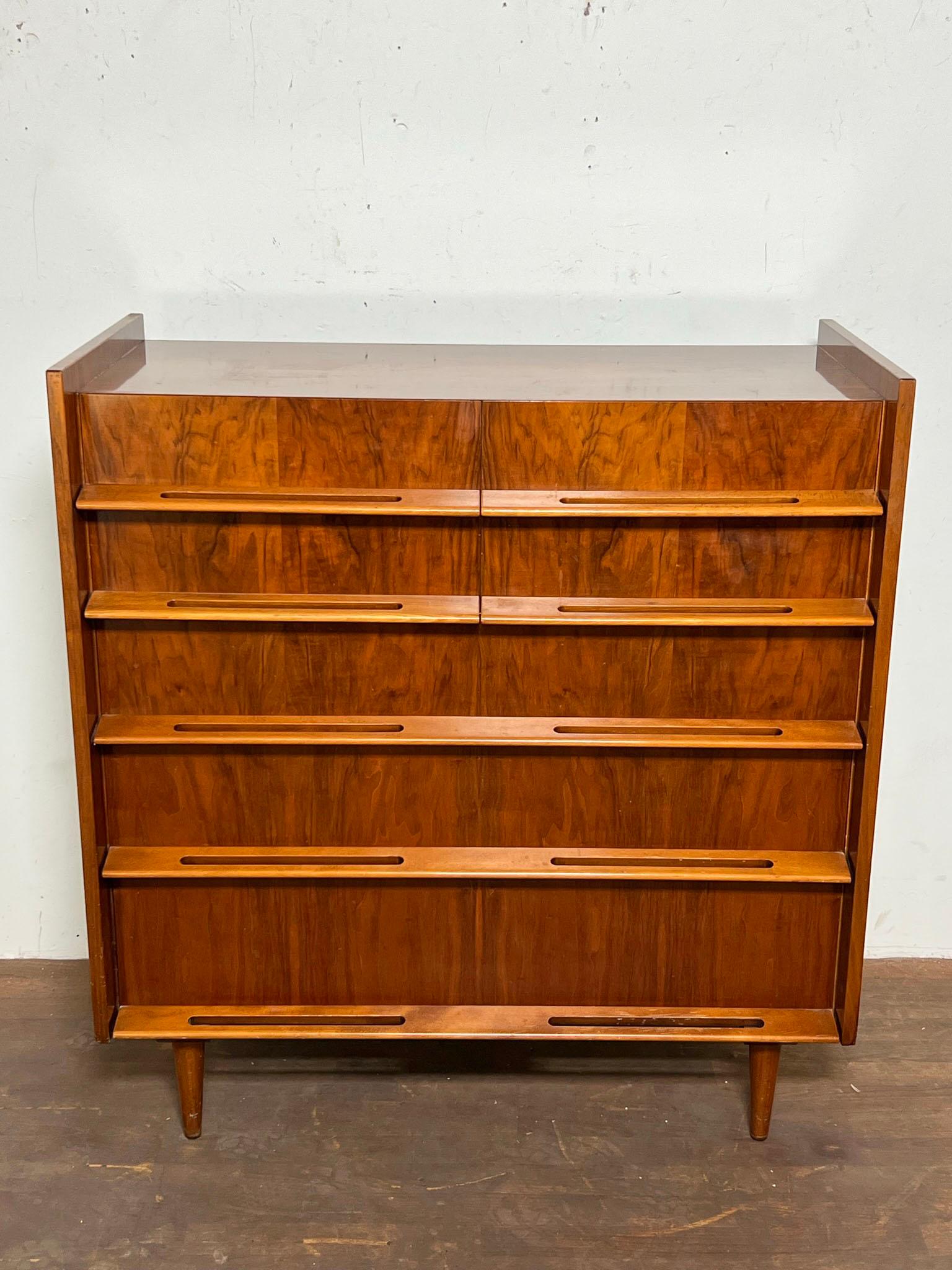 A seven drawer dresser from the Coronation Collection by Edmond Spence, introduced in 1953 as a tribute to that year’s crowning of Queen Elizabeth. Book matched teak with contrasting full length birch handles featuring slotted finger pulls.



