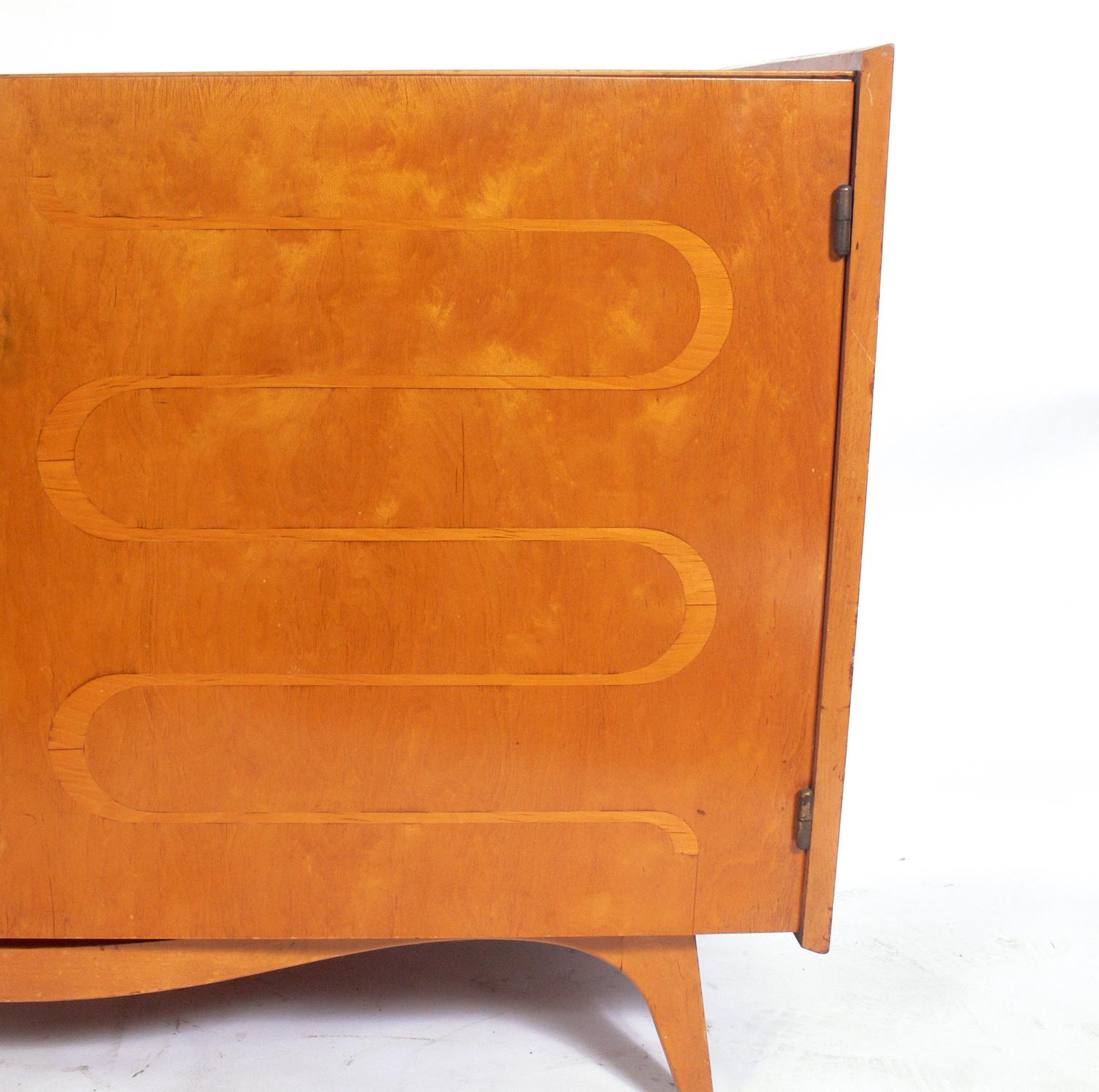 Elegant inlaid chest or credenza, designed by Edmund Spence, Sweden, circa 1950s. This piece offers a voluminous amount of storage with the two doors opening to reveal eight deep drawers and four adjustable shelves. It is a versatile size and can be