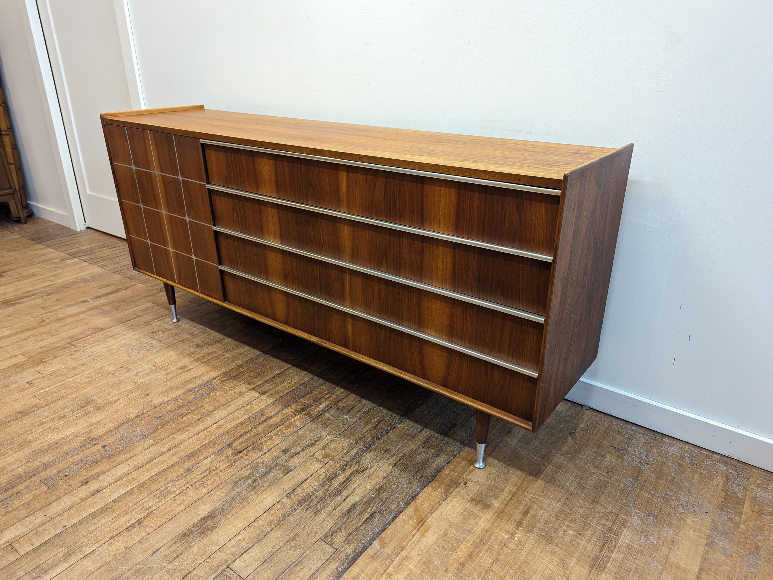Edmond Spence Walnut Credenza Sideboard.  Mid century credenza designed by Edmond J. Spence in walnut with aluminum pattern inlay to the door, aluminum track handles and raised edge sides.  Legs are tapered with aluminum sabot feet.  Inside has