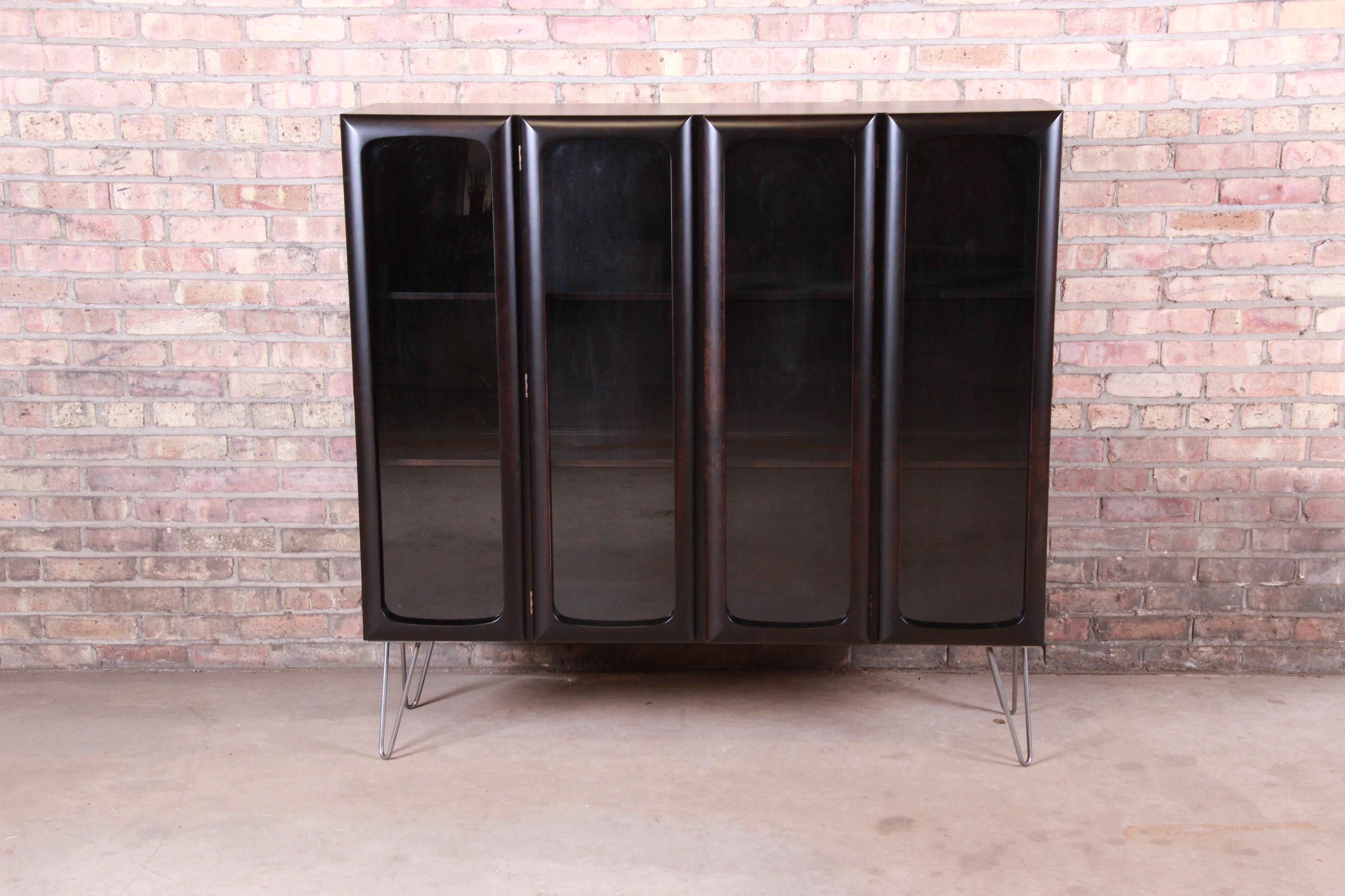 An exceptional midcentury Swedish Modern ebonized glass front bookcase cabinet on hairpin legs

By Edmond Spence

Sweden, 1950s

Newly ebonized birch case, with glass doors and steel hairpin legs.

Measures: 52.25