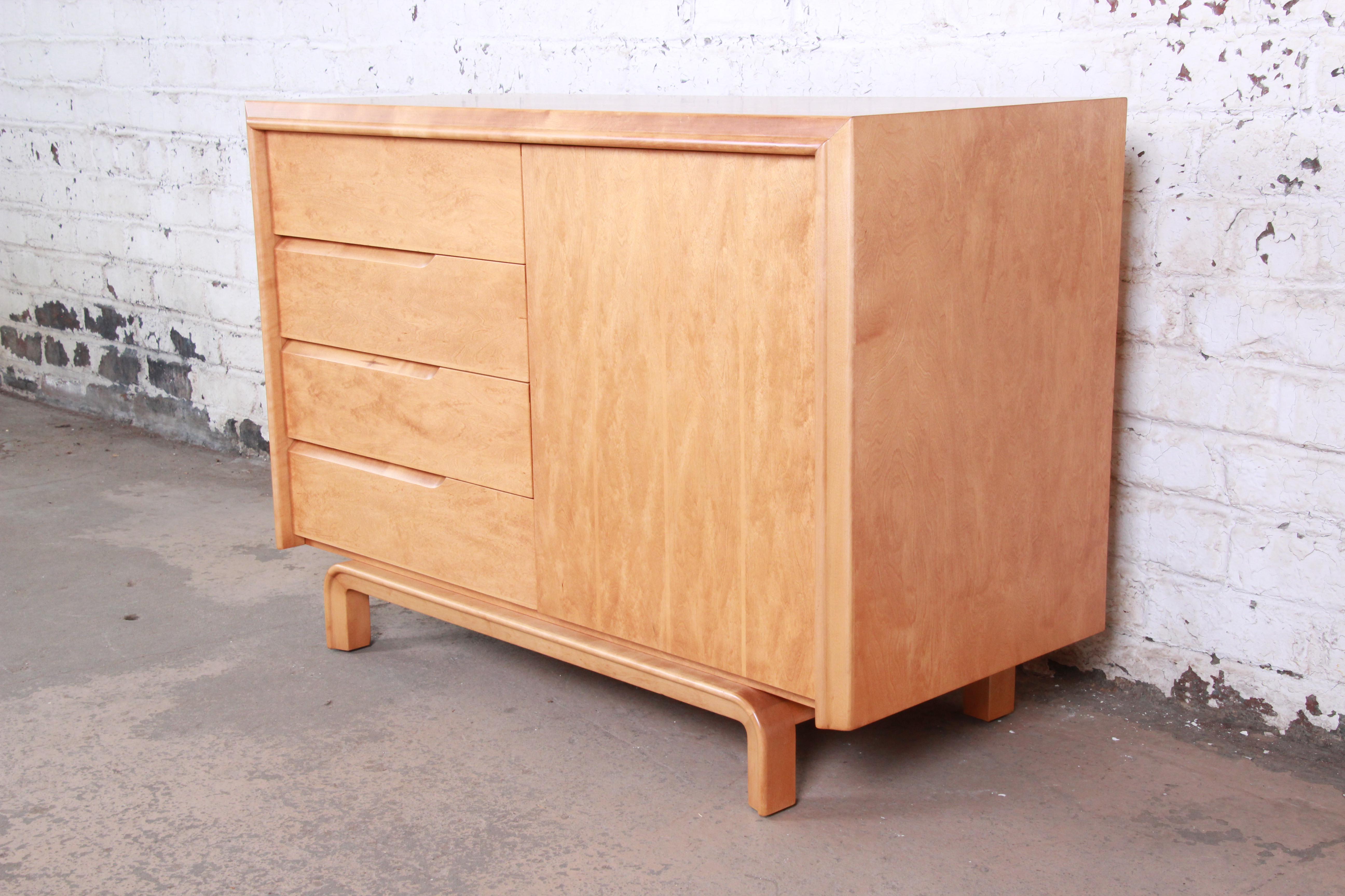 An exceptional Mid-Century Modern maple sideboard or credenza designed by Edmond Spence. The credenza features gorgeous maple wood grain and sleek Scandinavian design. It offers ample storage, with four deep dovetailed drawers on the left and a