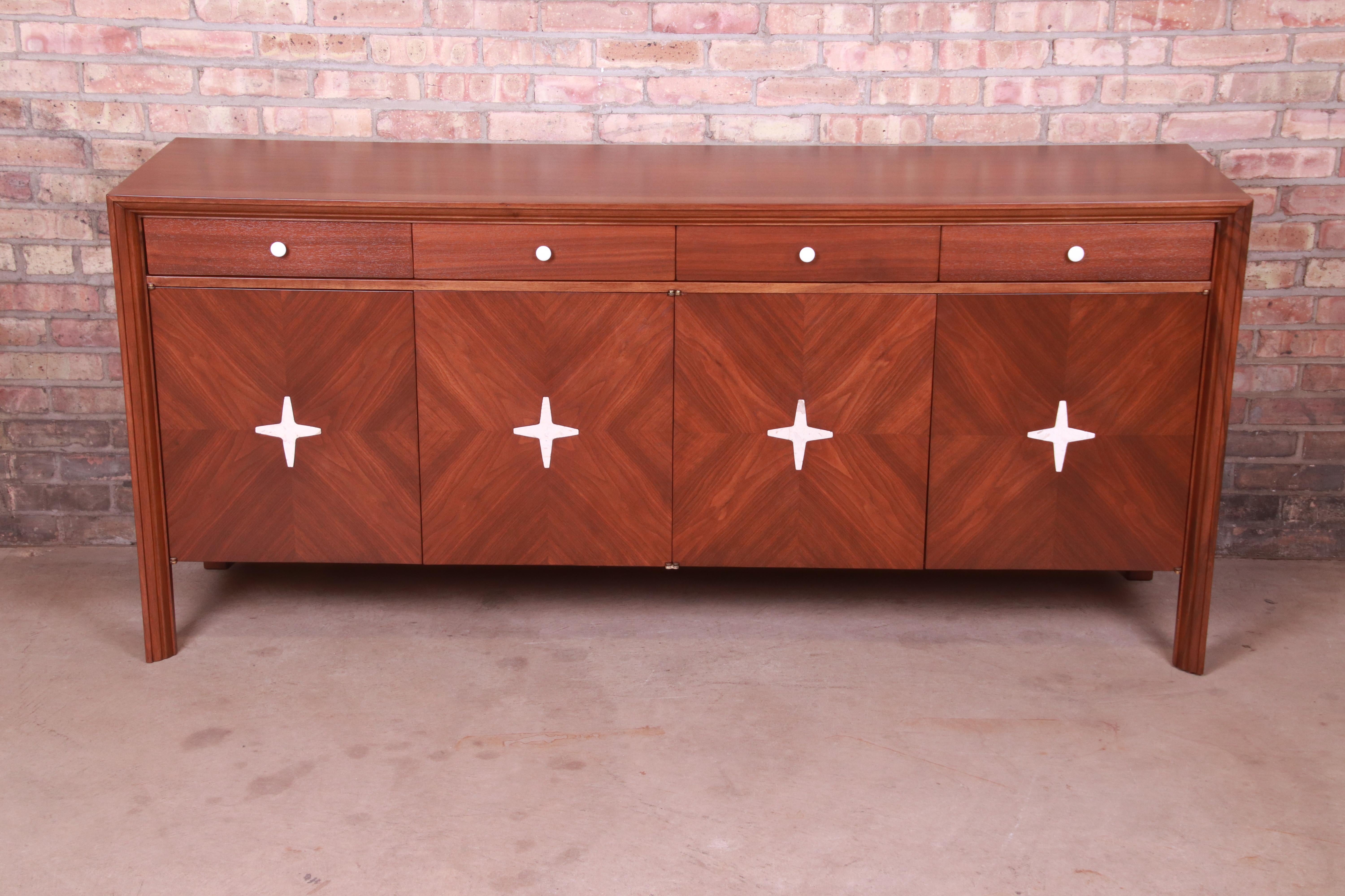 An exceptional mid-century Swedish Modern long dresser or credenza

By Edmond J. Spence

Sweden, 1950s

Beautiful inlaid walnut, with starburst travertine inlay and original porcelain drawer pulls.

Measures: 73.25